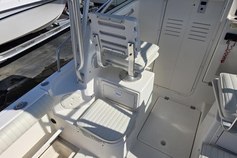 2004 Robalo R235 Walkaround boat interior with white seating and storage compartments.