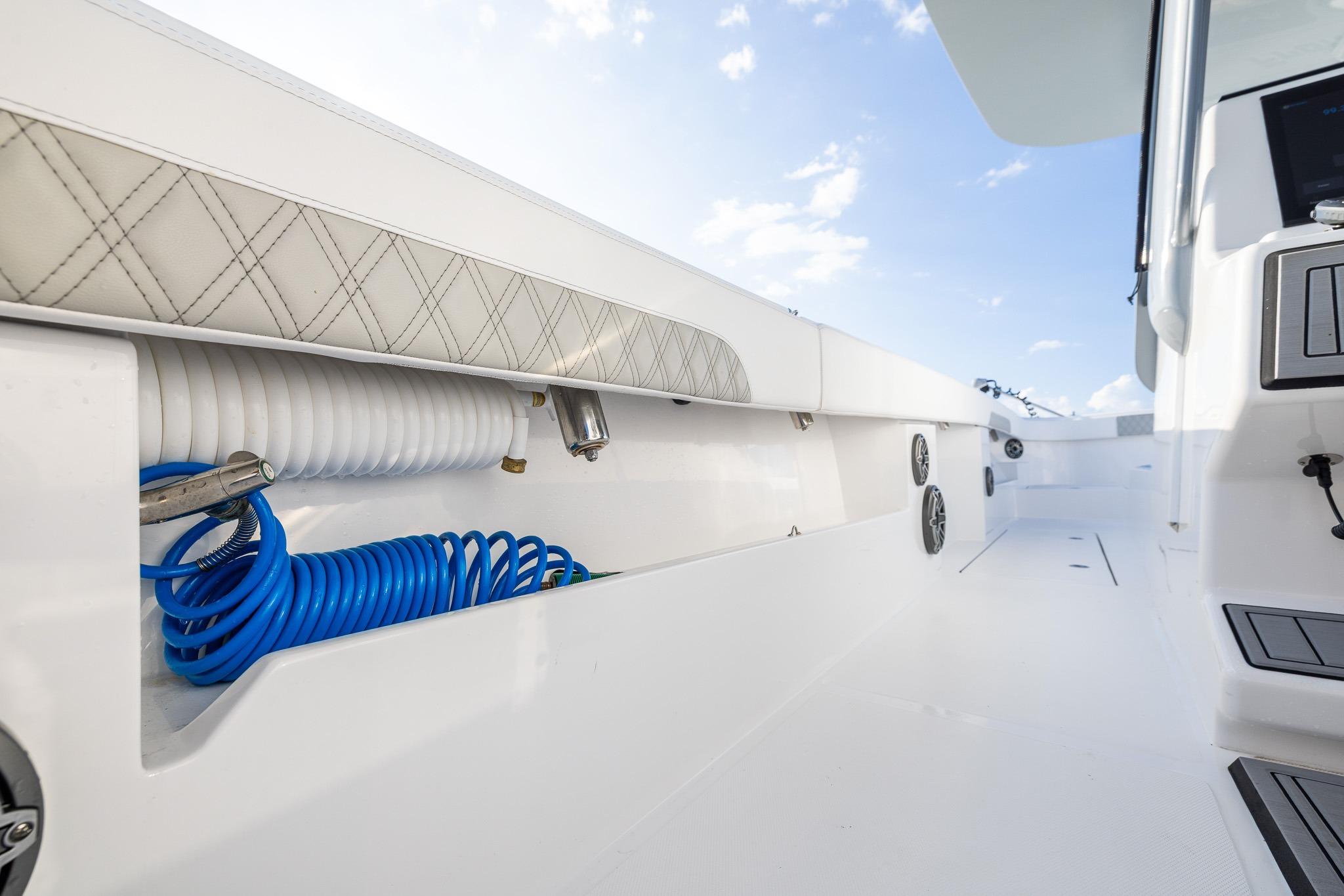 2026 Front Runner 37 Catamaran deck with storage compartment and coiled hose.