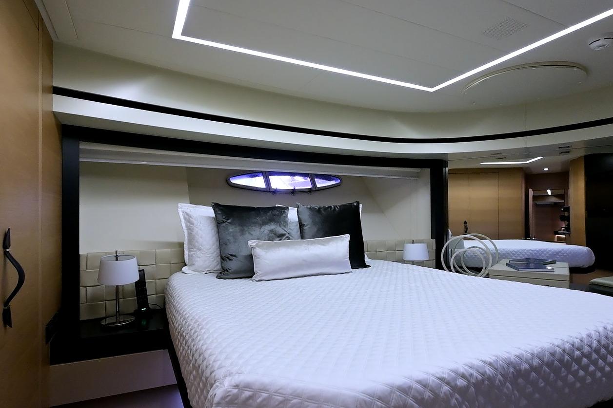 Luxurious bedroom interior of 2015 Pershing 92 yacht, featuring modern design and elegant bedding.