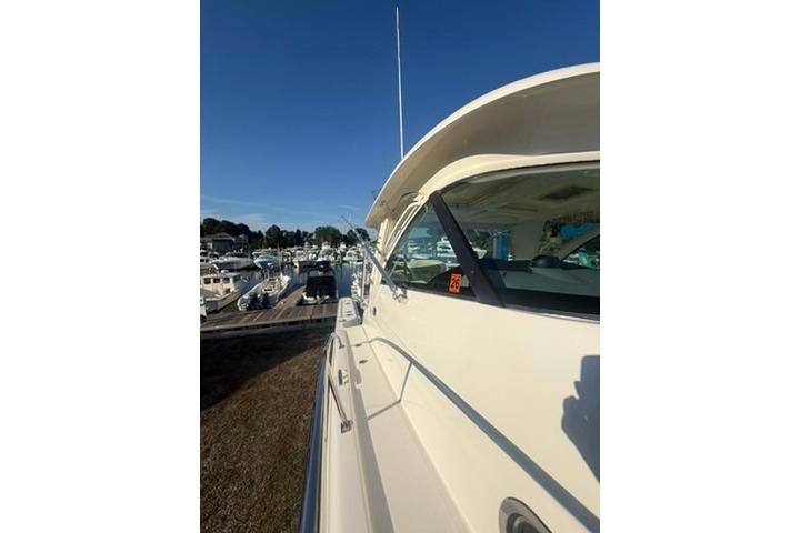 2010 Pursuit OS 375 Offshore boat docked at a marina under clear blue skies.