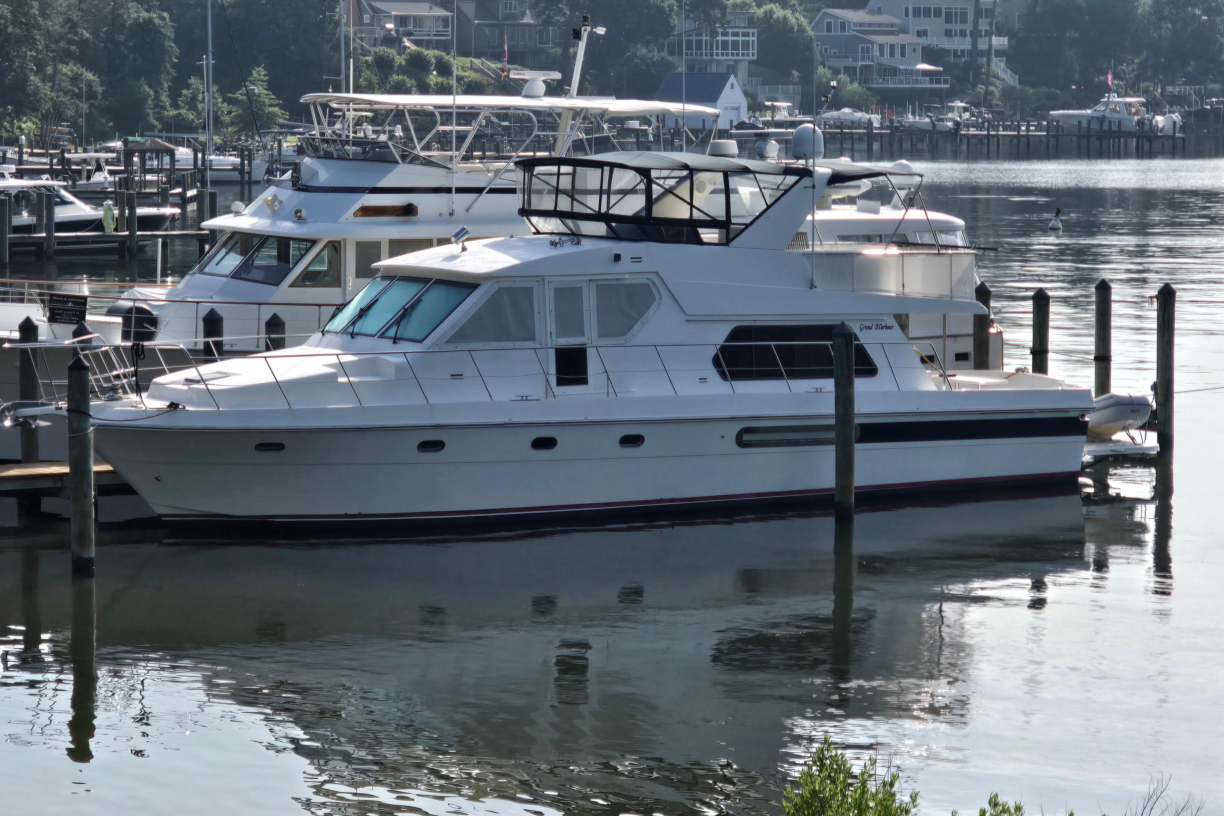 2004 Grand Harbour 58 yacht docked at a marina, reflecting on calm water.