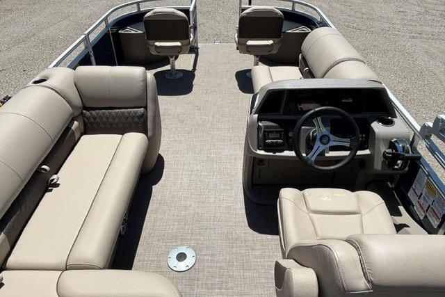 2025 Sun Tracker Fishin' Barge 22 DLX interior with beige seating and steering console.