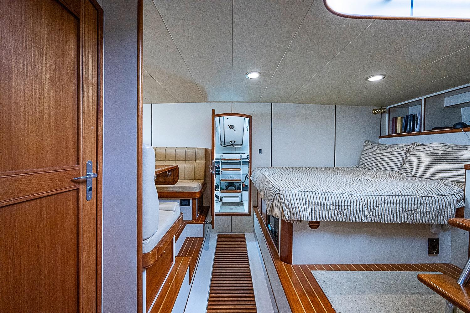 Interior of 2014 Marlow 80 Explorer yacht with cozy bed and seating area.