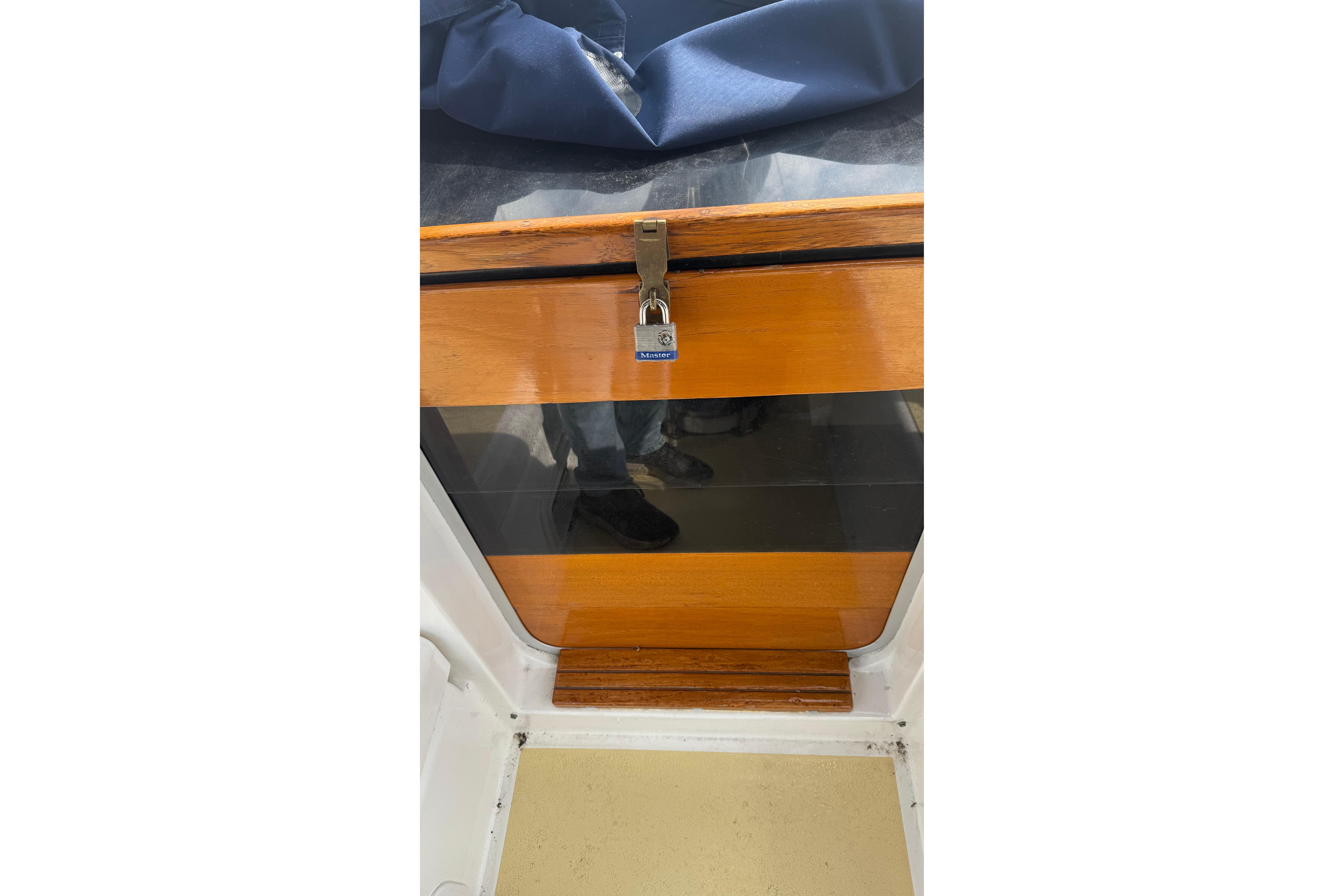 Wooden hatch with padlock on 1984 Hunter 31 sailboat.