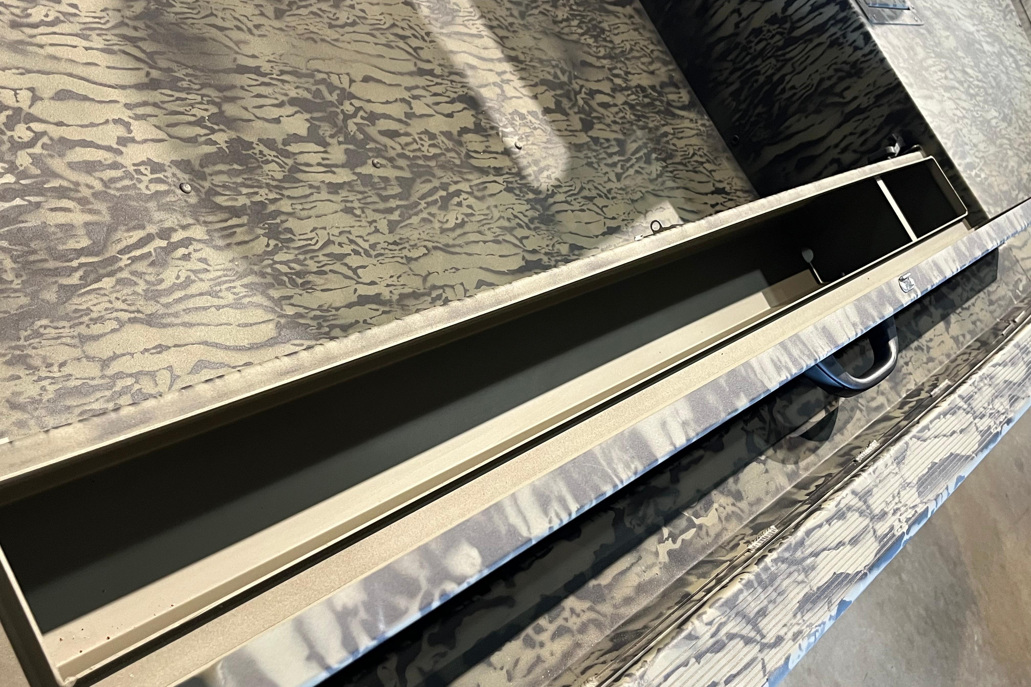 2026 Tracker Grizzly 1654 T Sportsman boat interior with camouflage pattern and storage compartment.