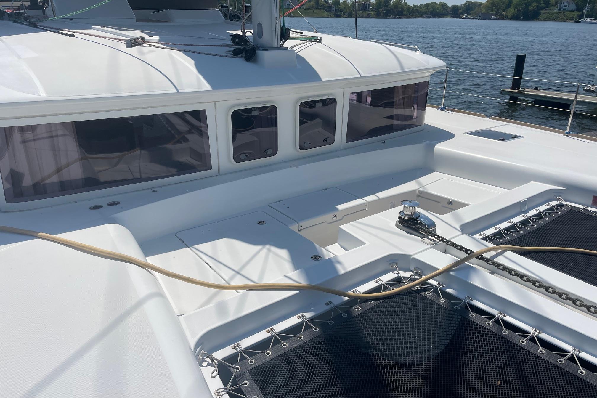 2016 Lagoon 450 F catamaran deck with winch and netting, docked by the water.