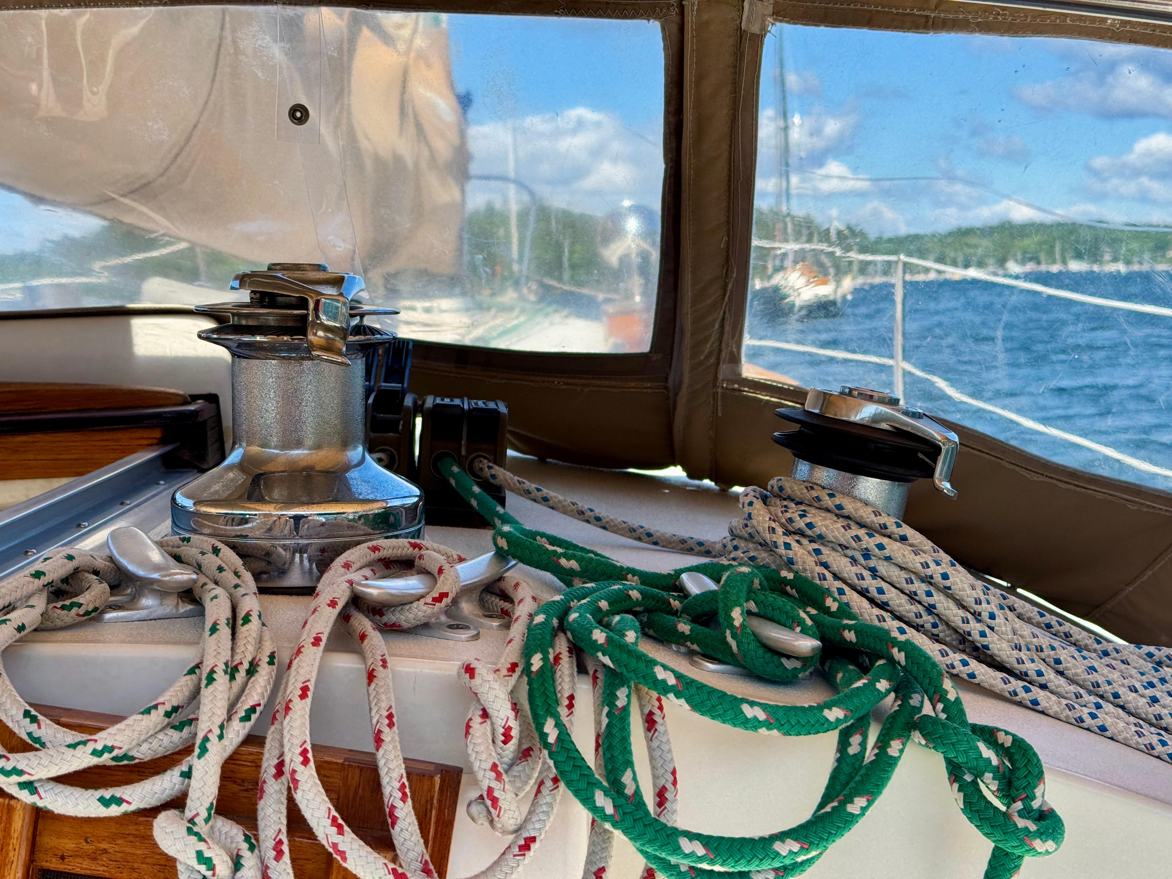 Sailing ropes and winches on a 1989 Nonsuch 30 Ultra boat, with a scenic water view.