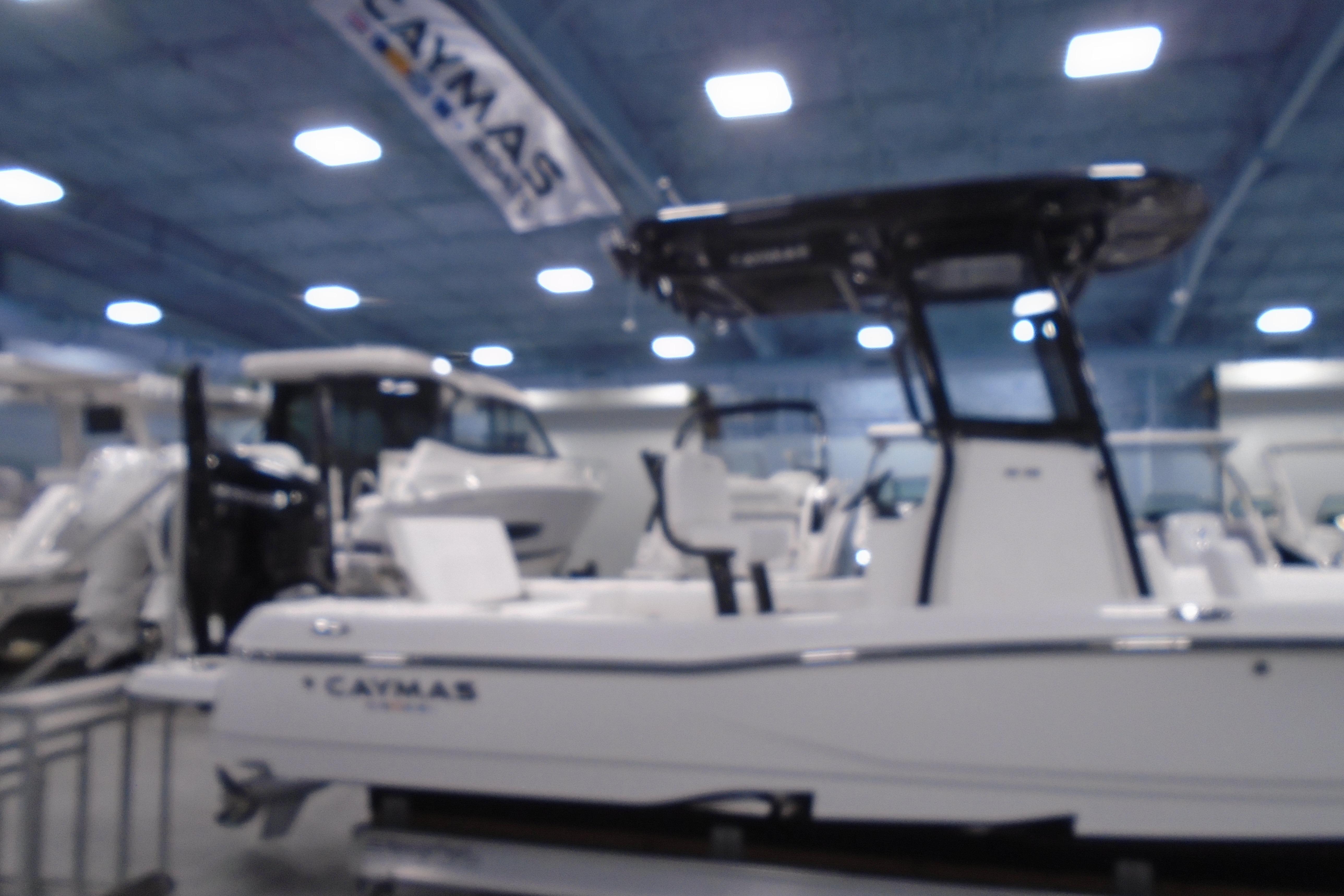 2026 Caymas 26 HB boat displayed indoors at a showroom.