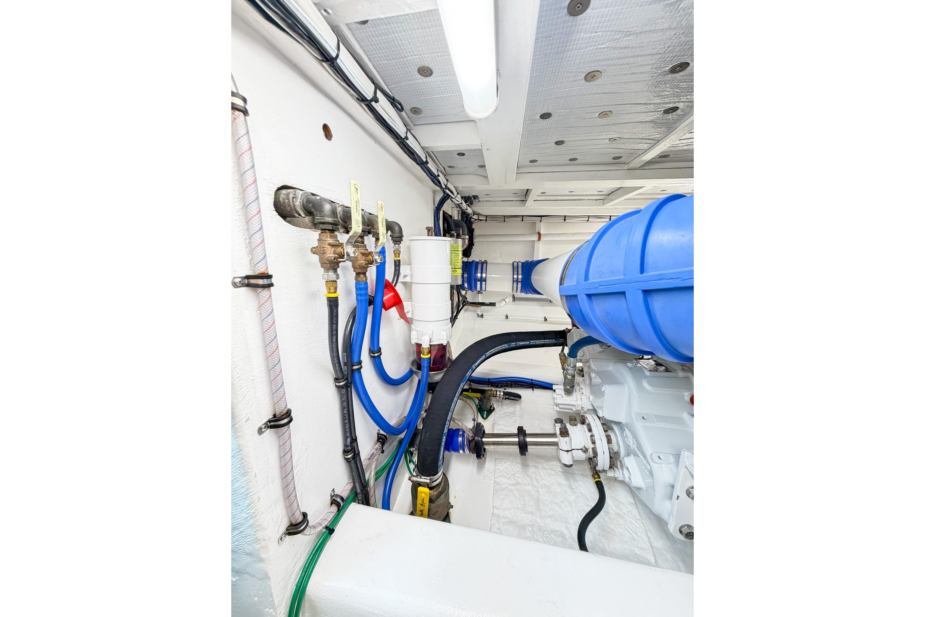Engine room of 1998 Blackwell Custom Carolina Sportfish with blue hoses and mechanical components.