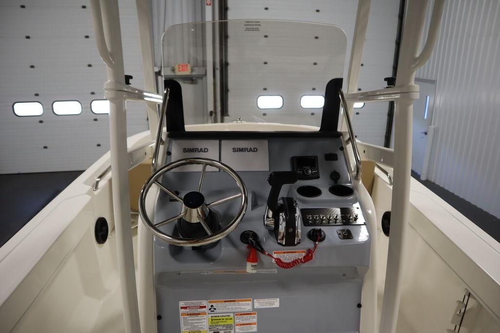 2026 Bayliner Trophy T20CC boat console with steering wheel and controls in a garage setting.