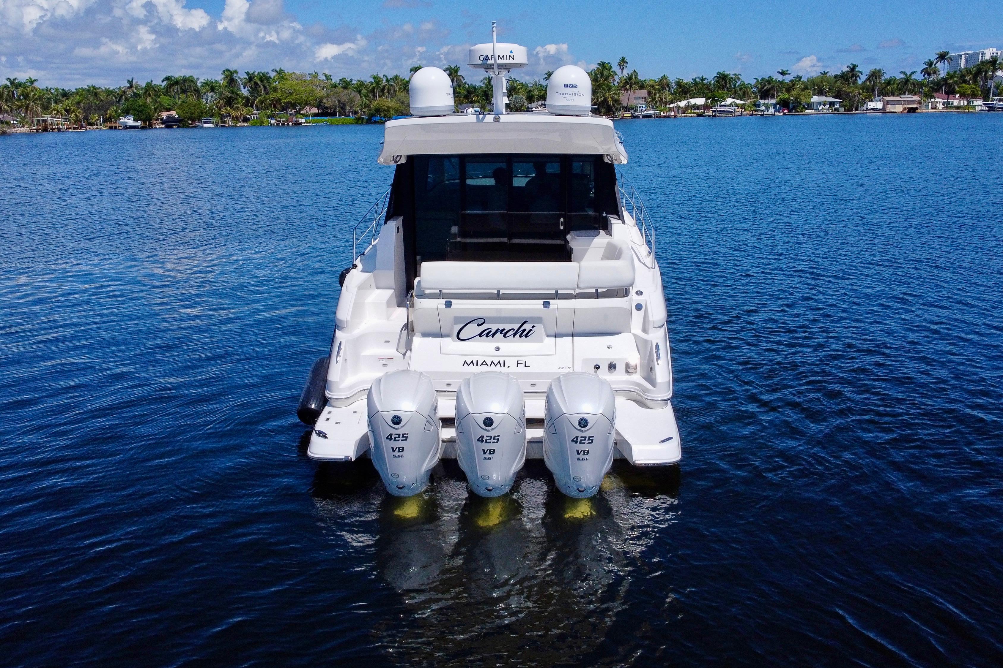 2022 Regal 42 XO yacht with triple 425 engines on a serene waterway.