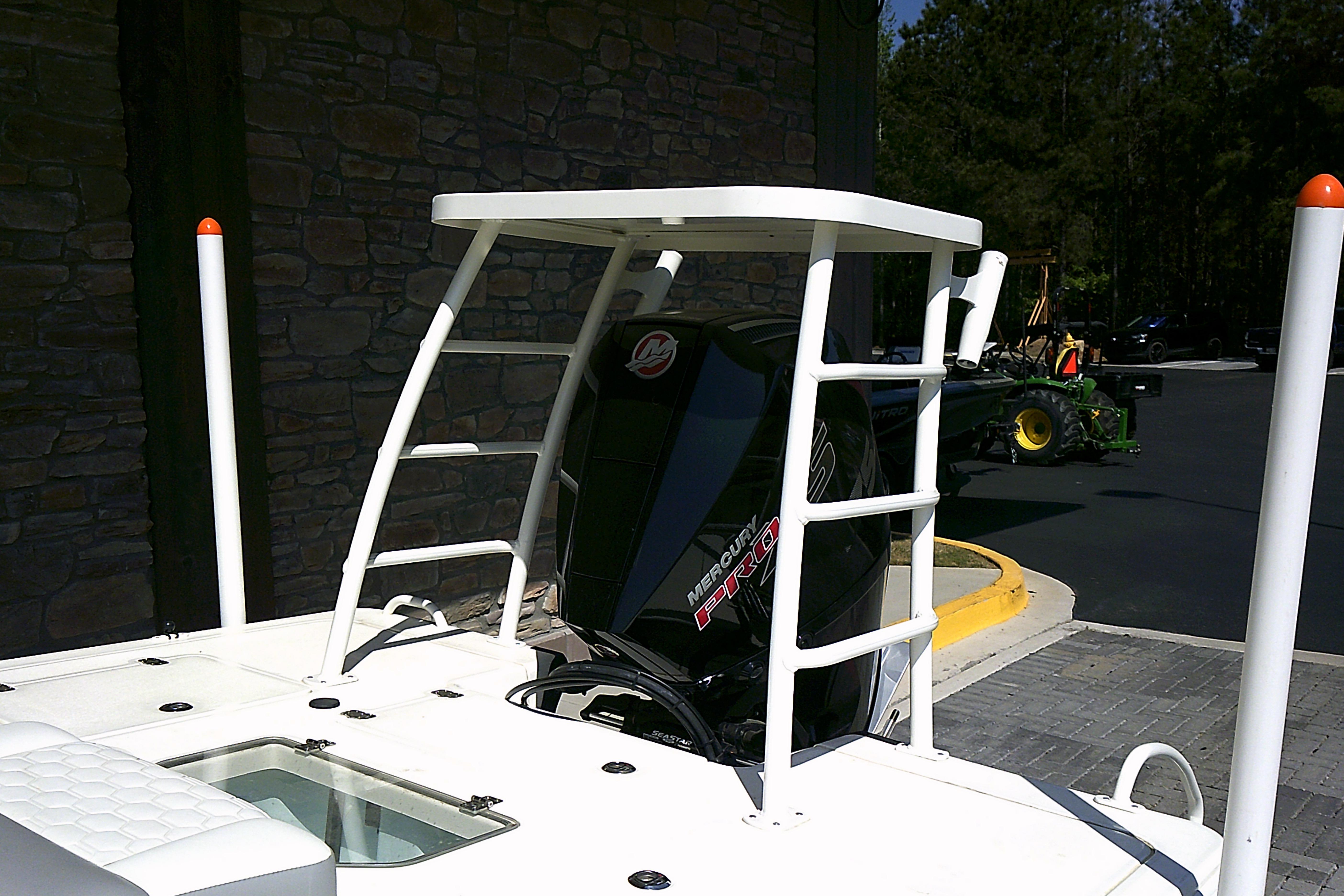 2026 Mako 18 Pro Skiff boat with Mercury engine, parked outdoors.