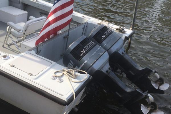 1987 Boston Whaler Cuddy Tower with twin V225 engines and American flag on water.