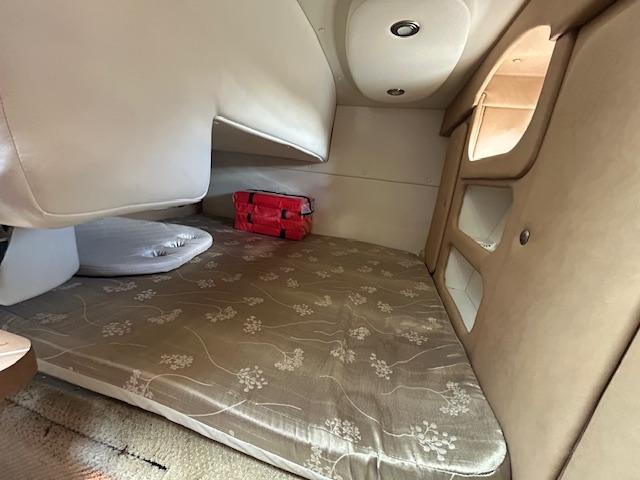 2013 Rinker 290 Express Cruiser cabin interior with bed and storage.