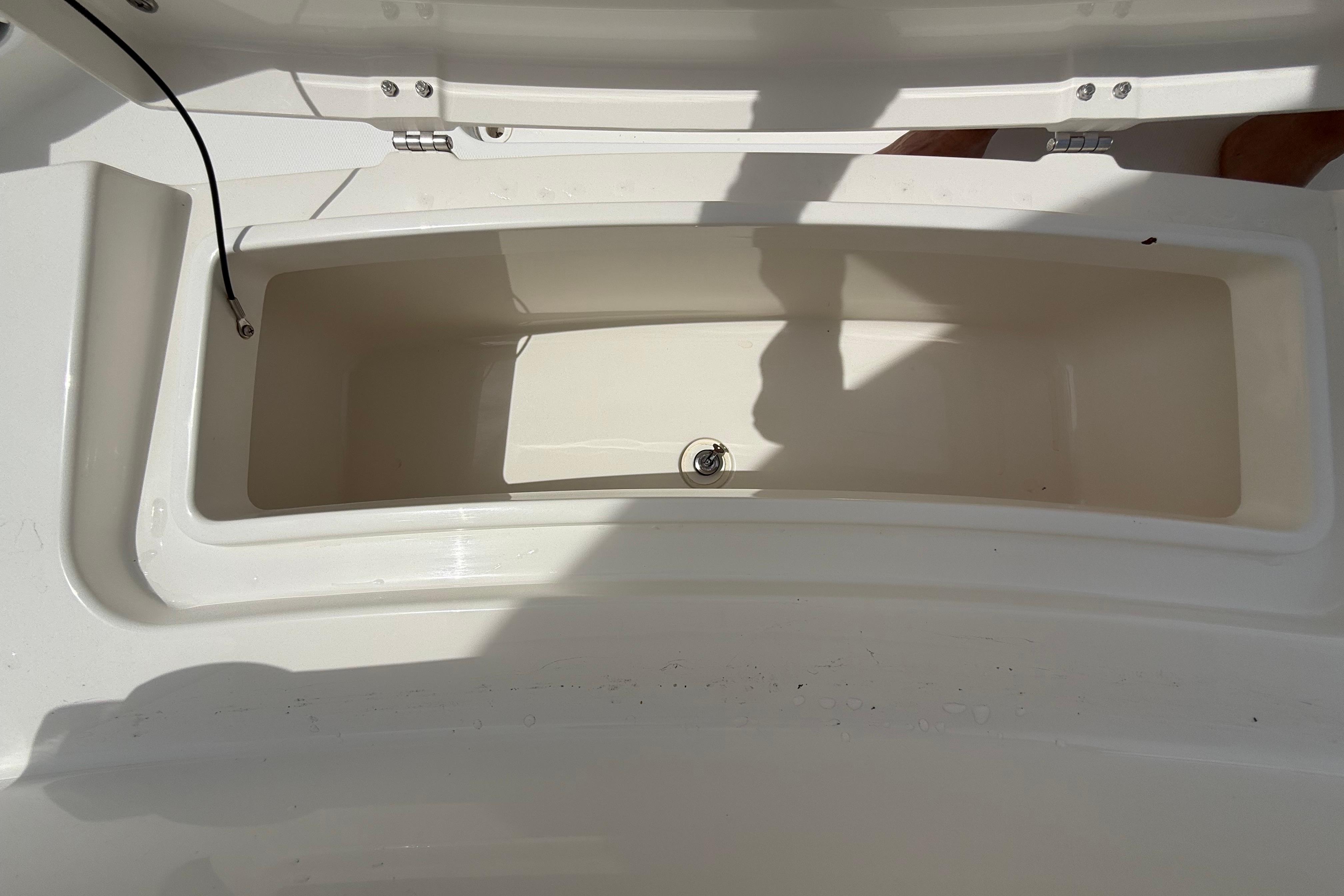 Open storage compartment on a 2019 Regulator 26XO boat, showing interior space.