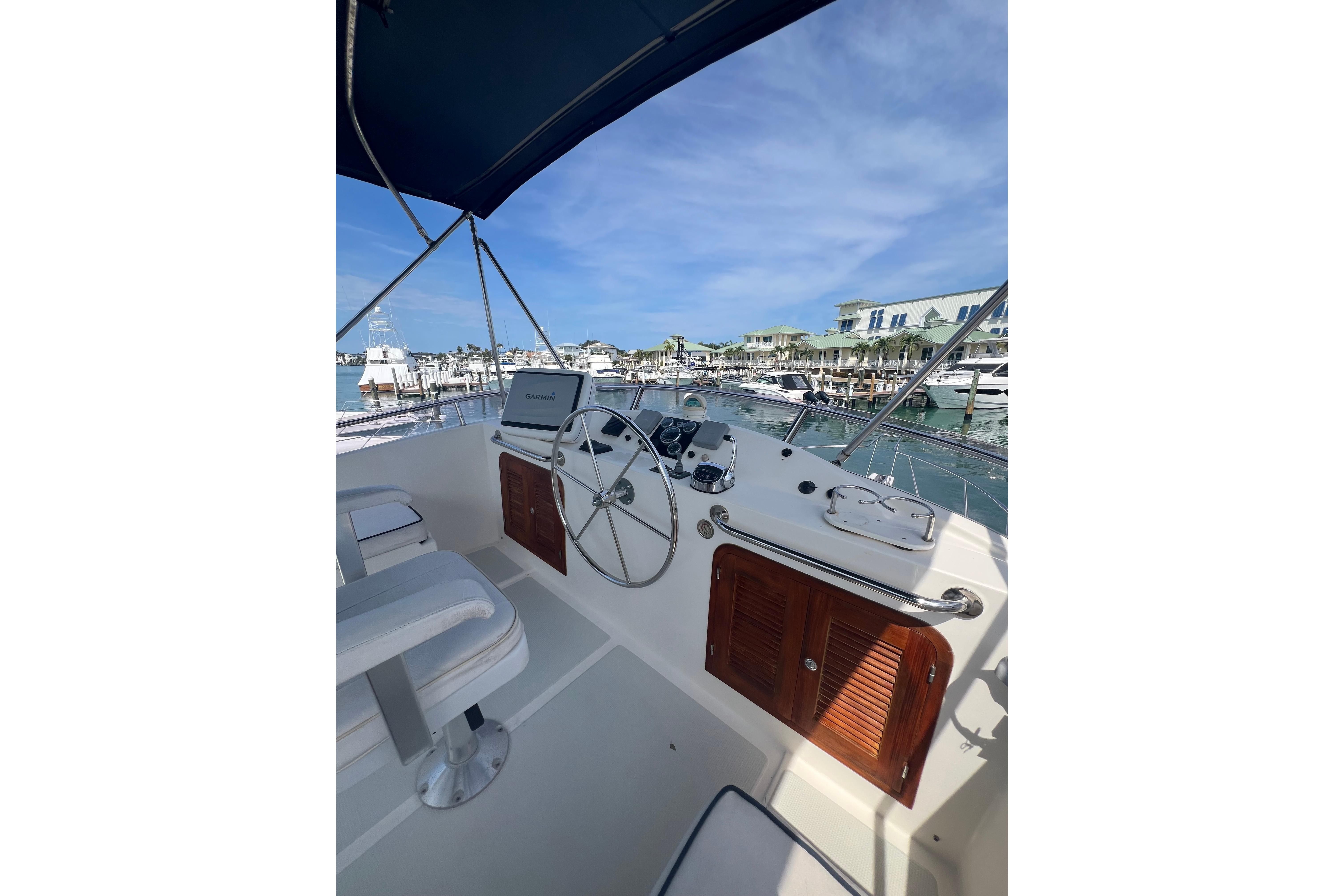 Helm of 2007 Heritage East 36 Sundeck Trawler with marina view.