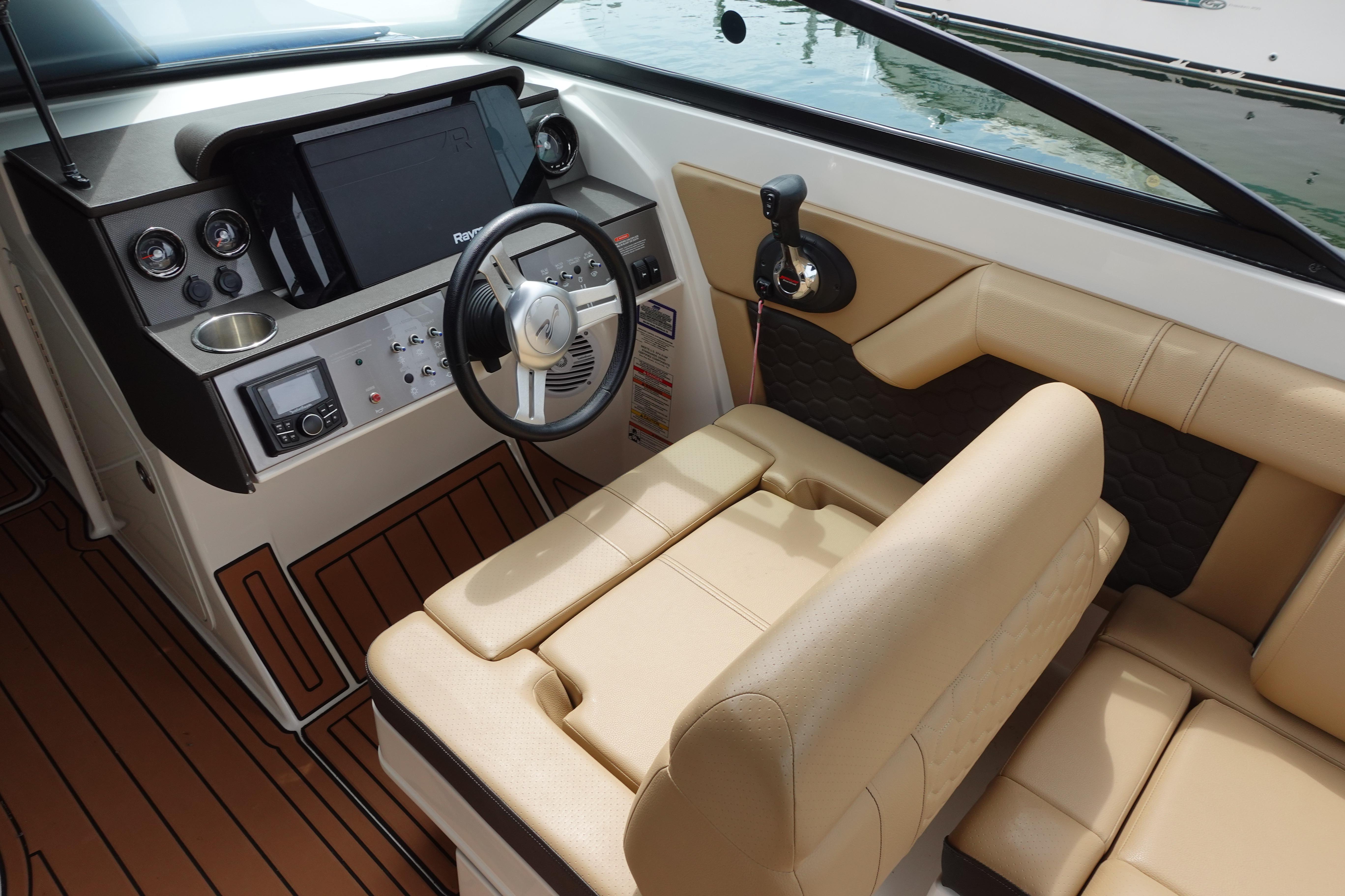 2018 Sea Ray SDX 270 boat cockpit with steering wheel and beige seating.