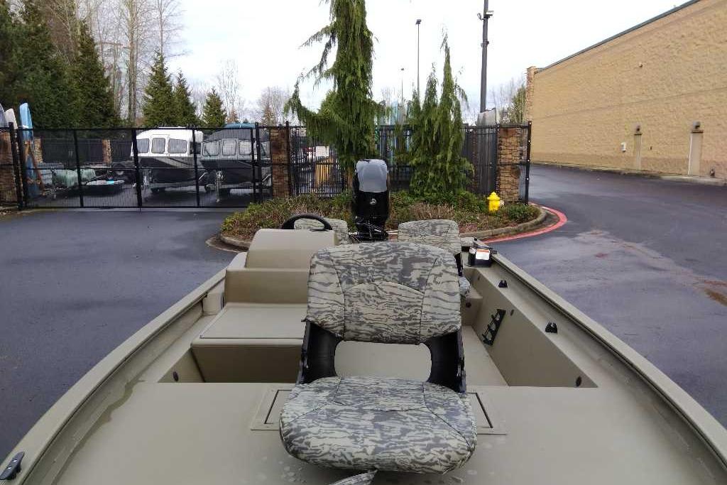 2026 Tracker Grizzly 1754 SC boat with camo seats, parked outdoors.