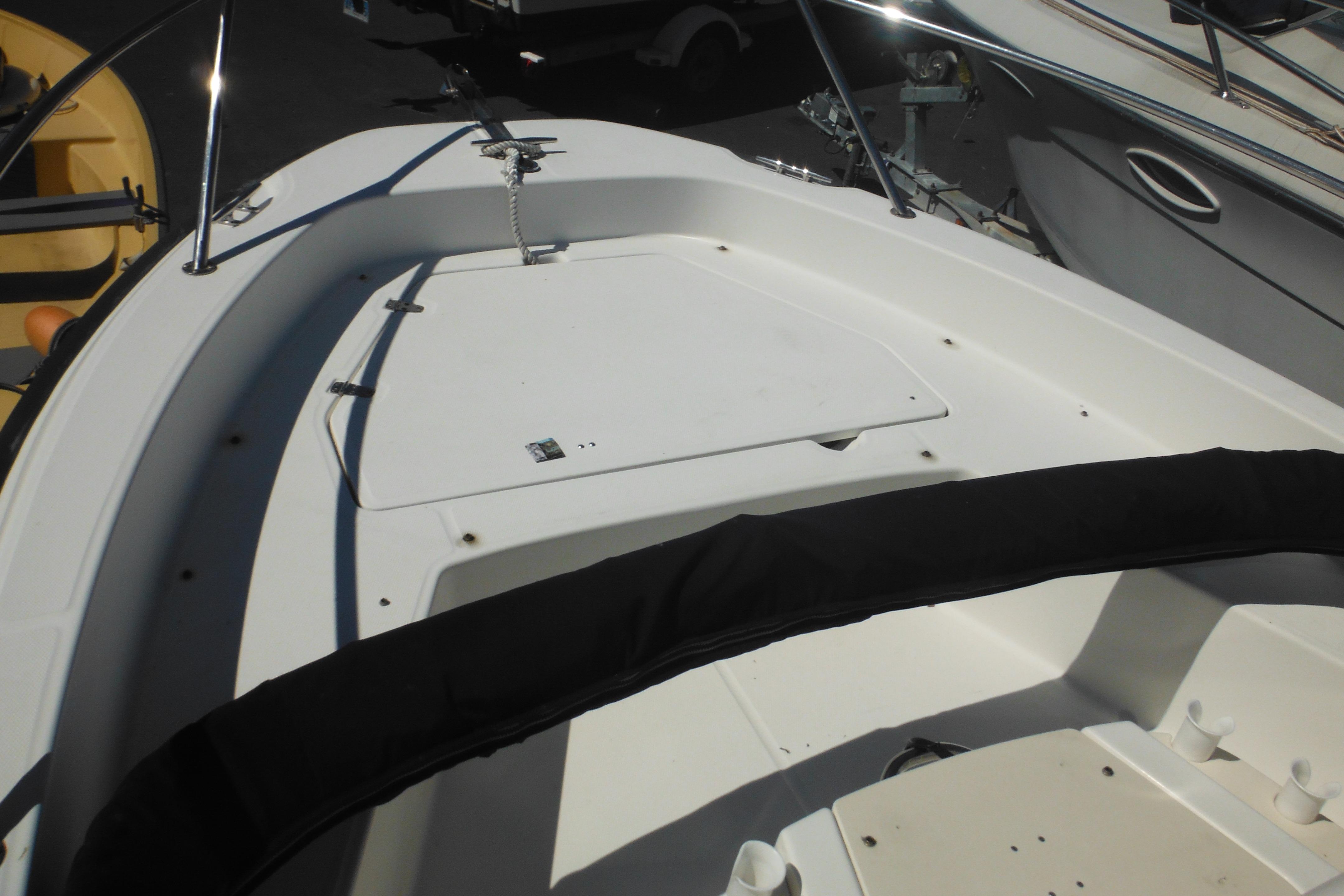 2009 Boston Whaler 200 Dauntless boat deck with storage compartment and railing.