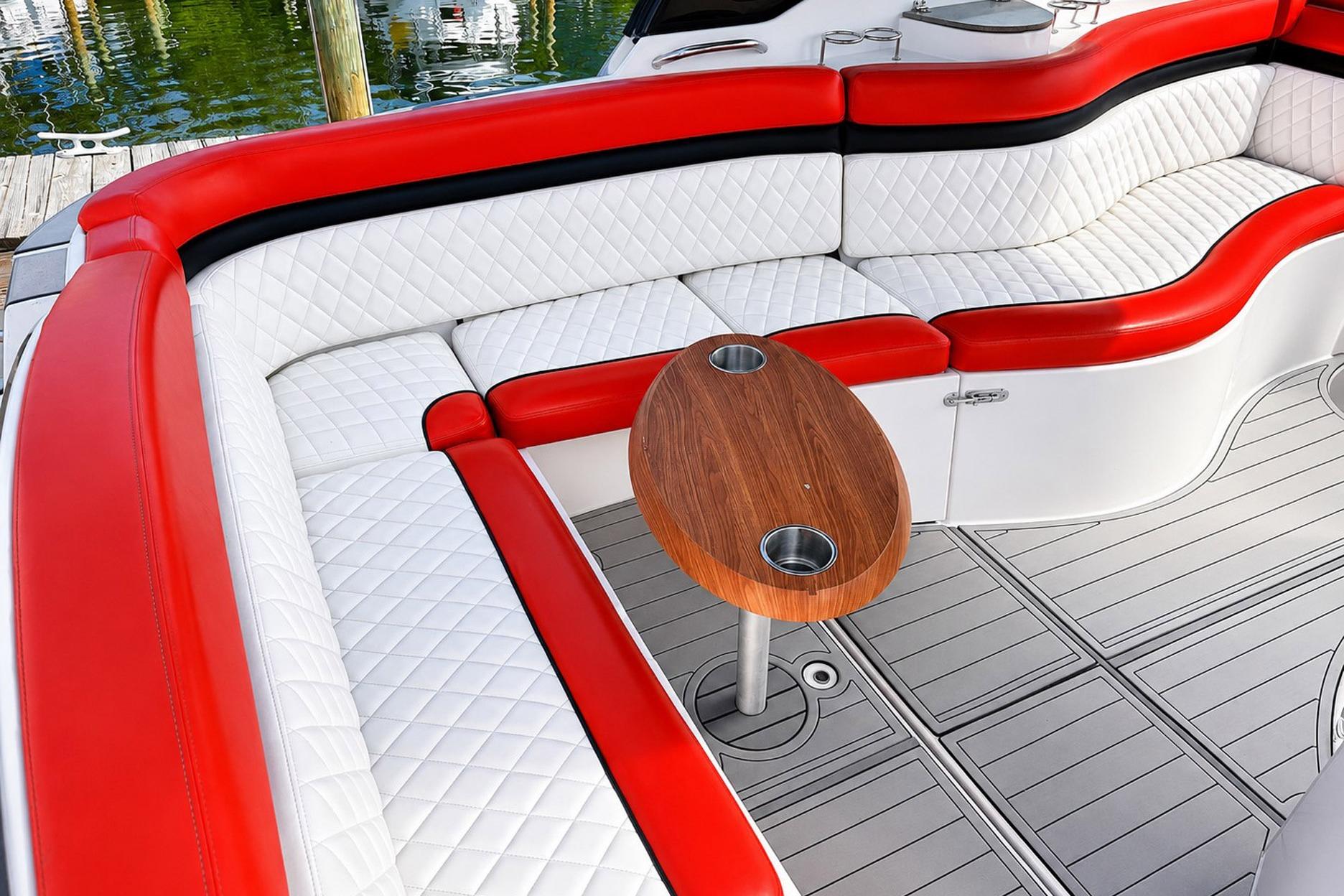 Luxurious seating on 2012 Rinker 310 Express Cruiser LE with red and white upholstery.