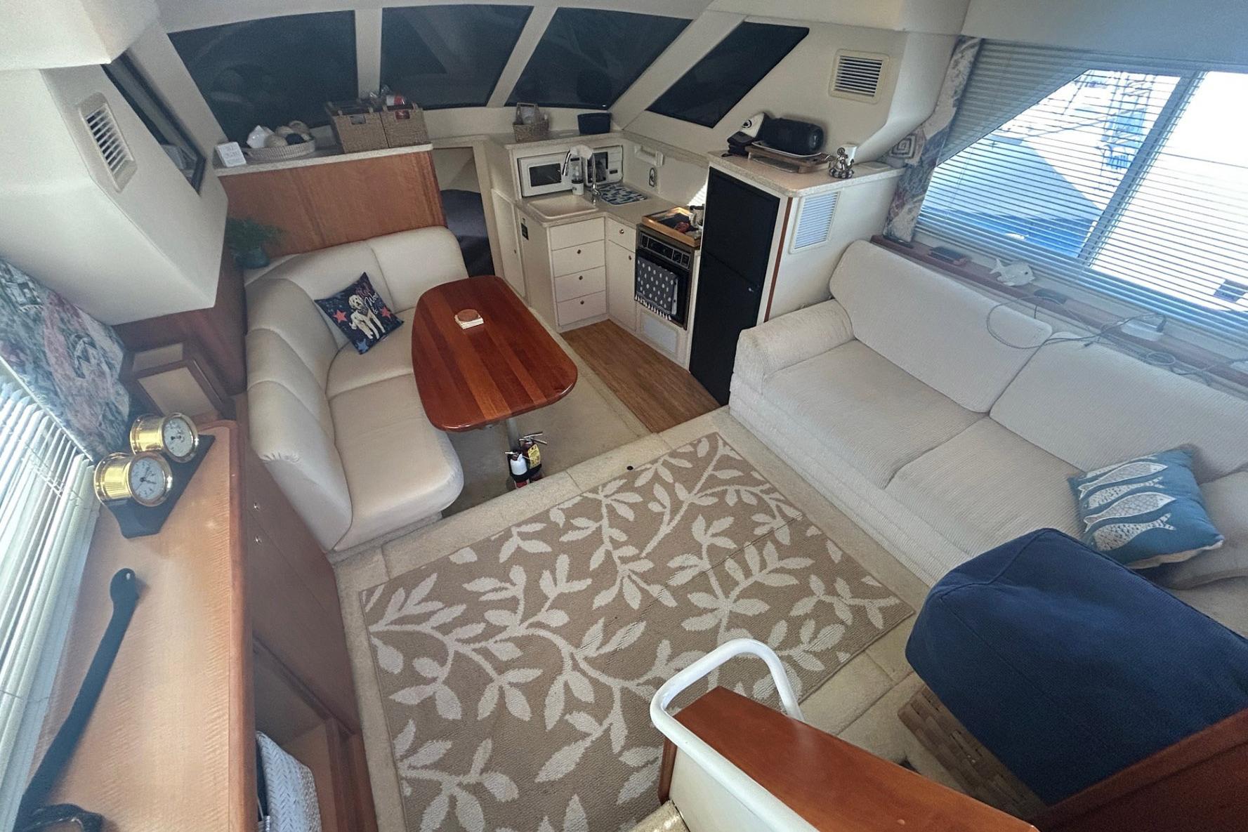 Interior of 2000 Silverton 352 Motor Yacht with cozy seating and nautical decor.