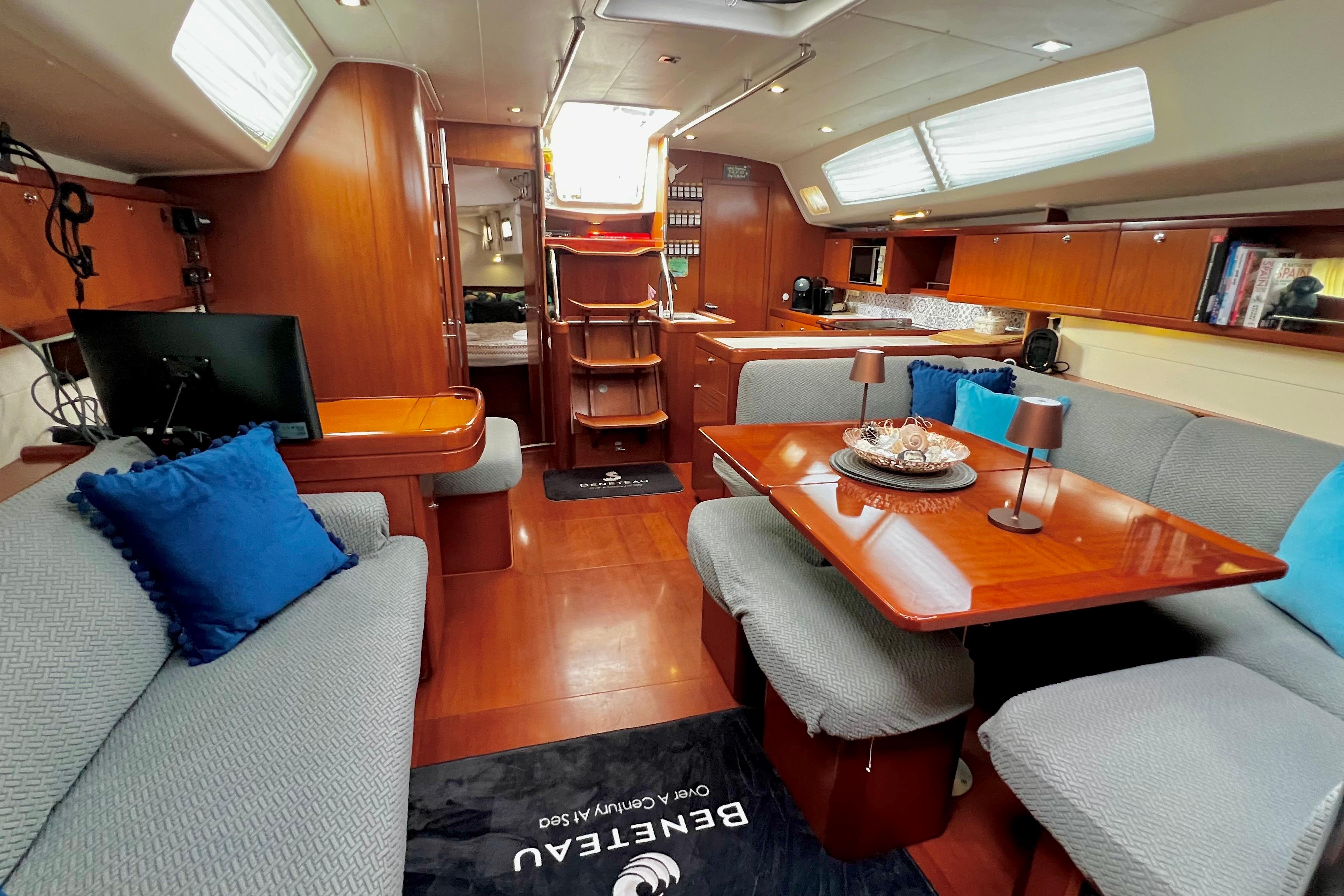 Luxurious interior of 2006 Beneteau Oceanis 50 yacht with elegant wood finishes and cozy seating.