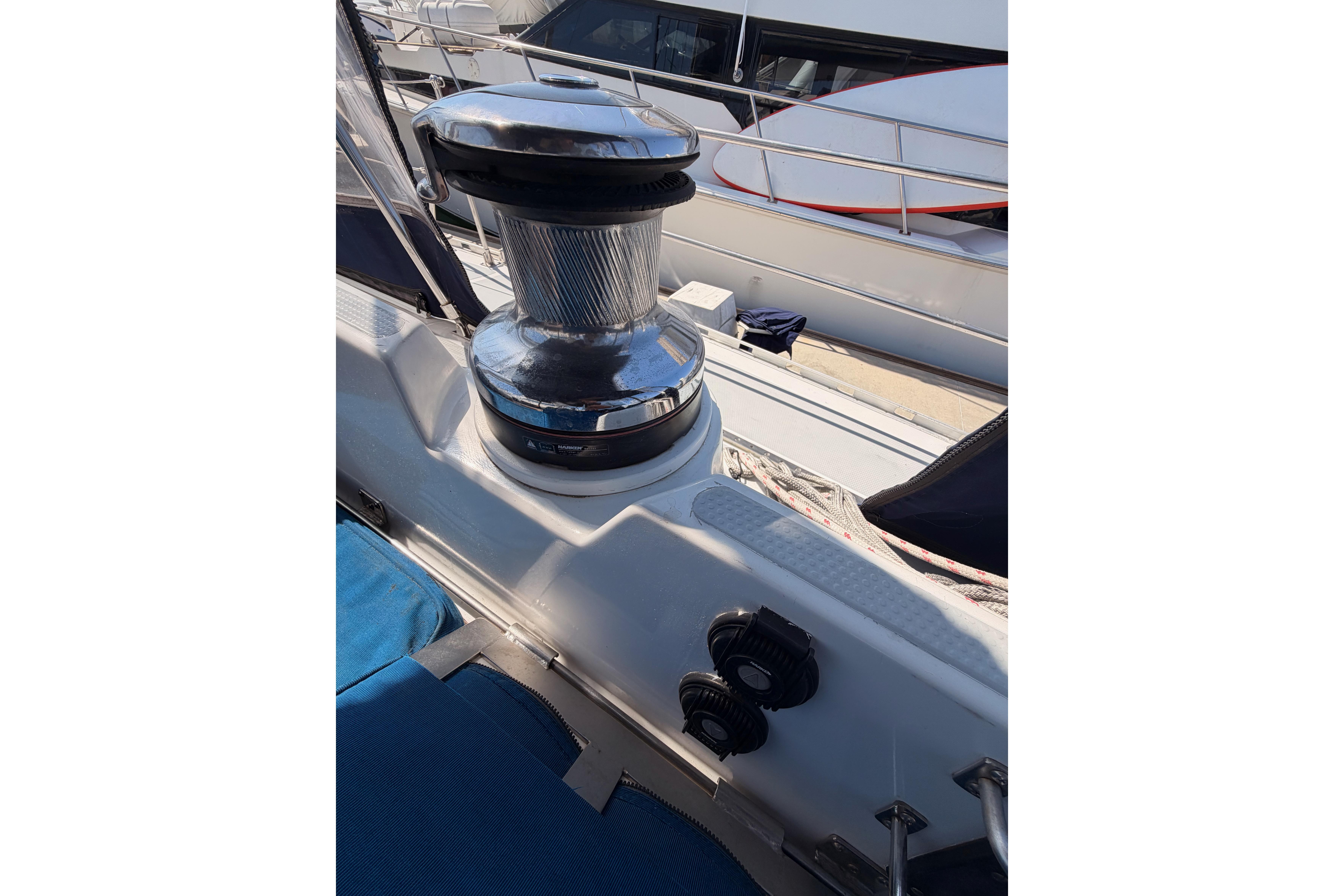 Winch on 1991 Hylas 51 sailboat deck, with ropes and railing visible.