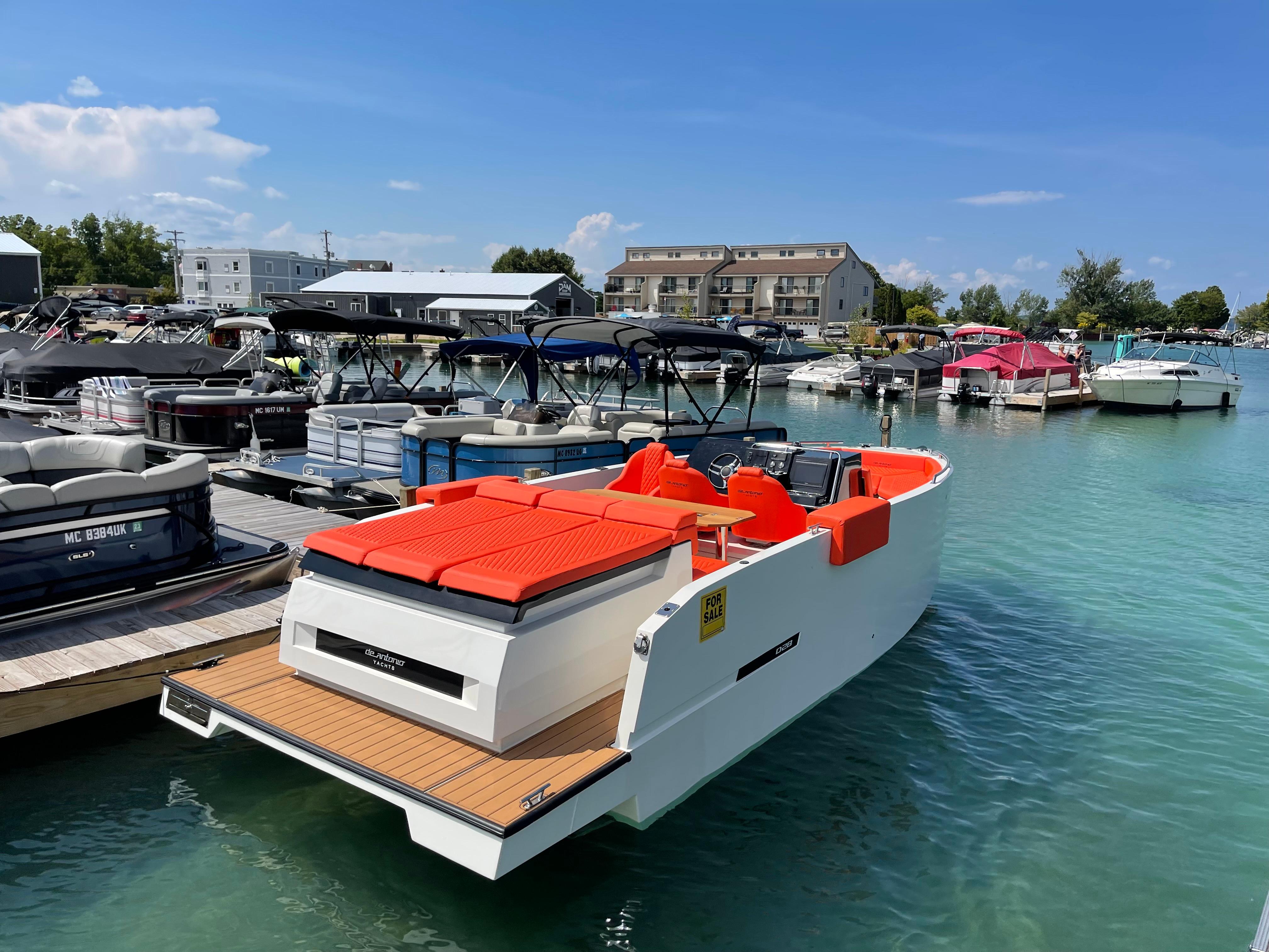 2020 De Antonio Yachts D 28 docked in a marina with vibrant orange seating.
