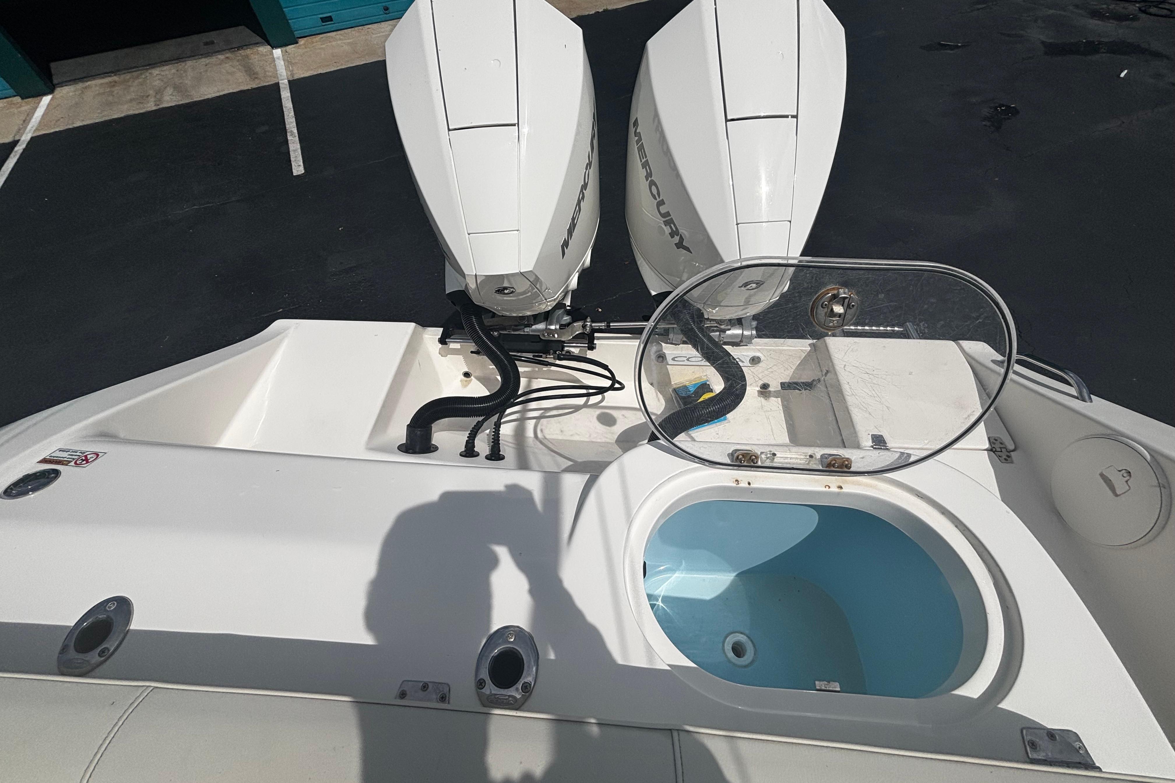2023 Cobia 262 Center Console boat with dual Mercury engines and open livewell.