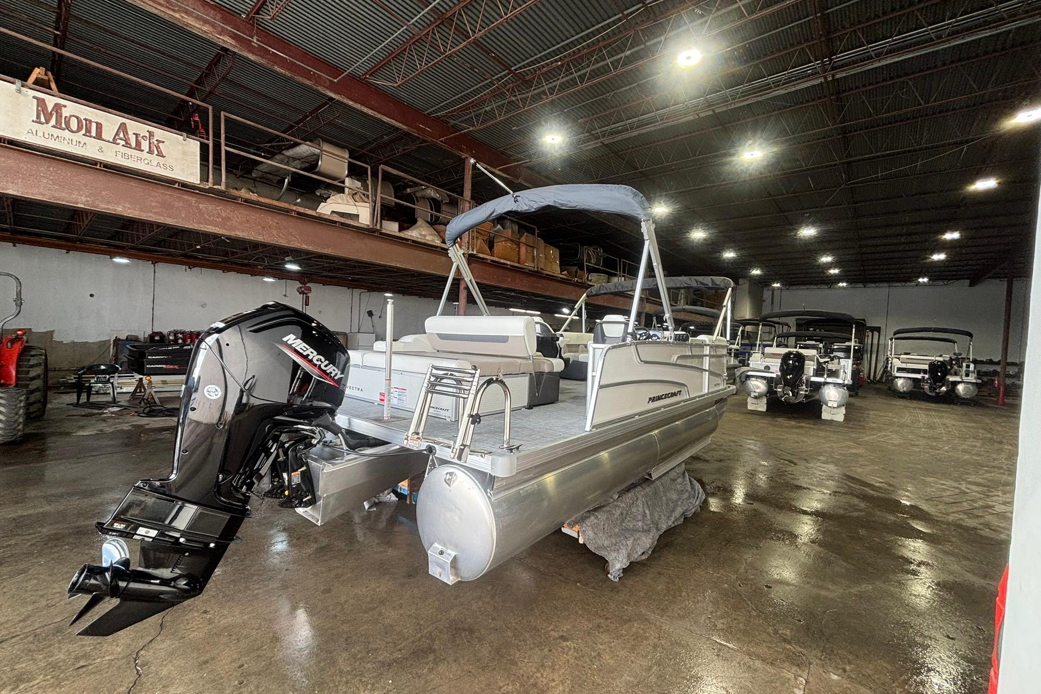 2025 Princecraft Vectra 21 RL pontoon boat in a spacious indoor showroom.