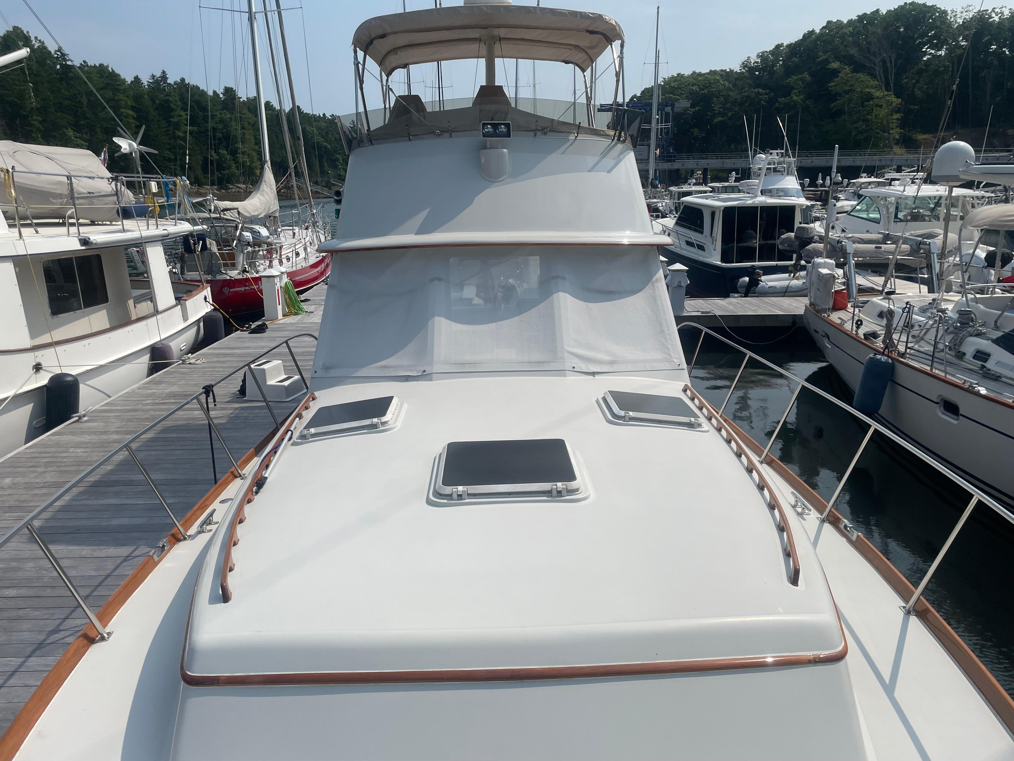 1997 Lyman-Morse Custom Flybridge yacht docked at a marina, surrounded by other boats.