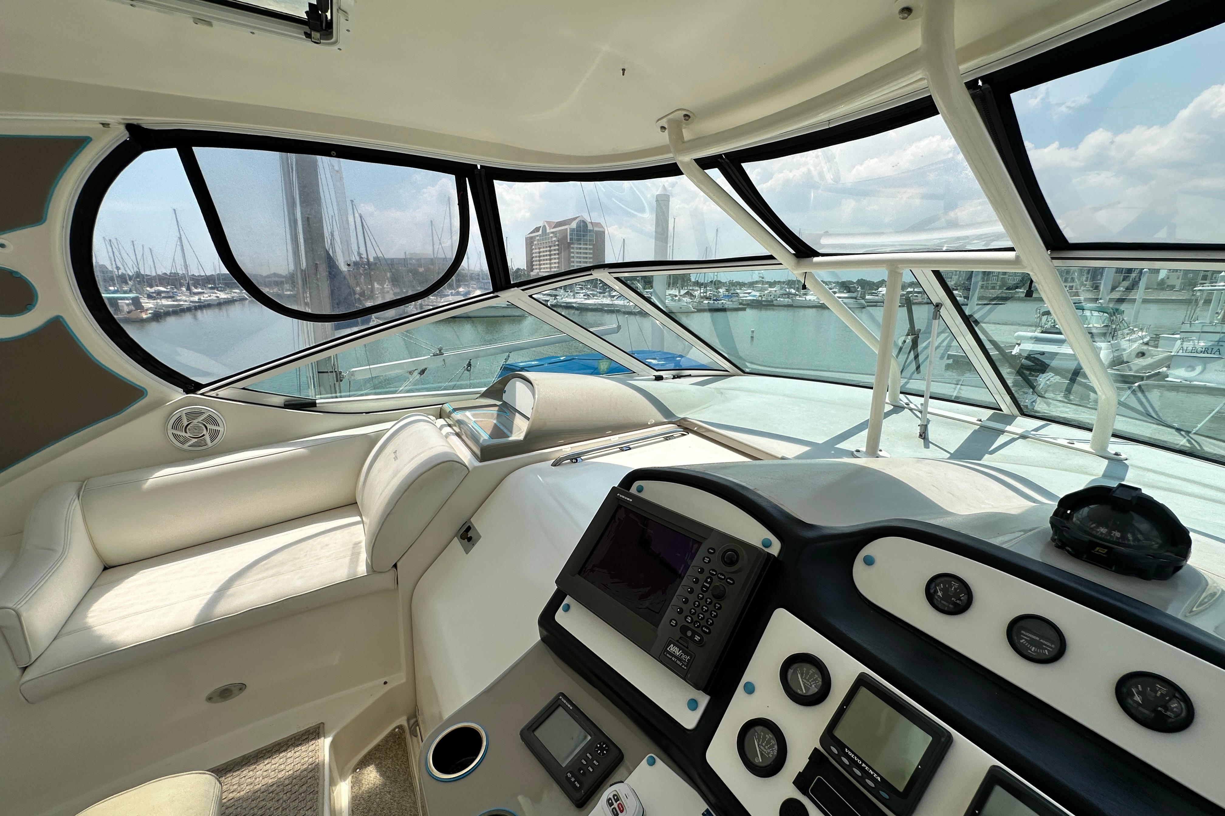 2004 Cruisers Yachts 405 Express Motoryacht helm with marina view, featuring navigation instruments.