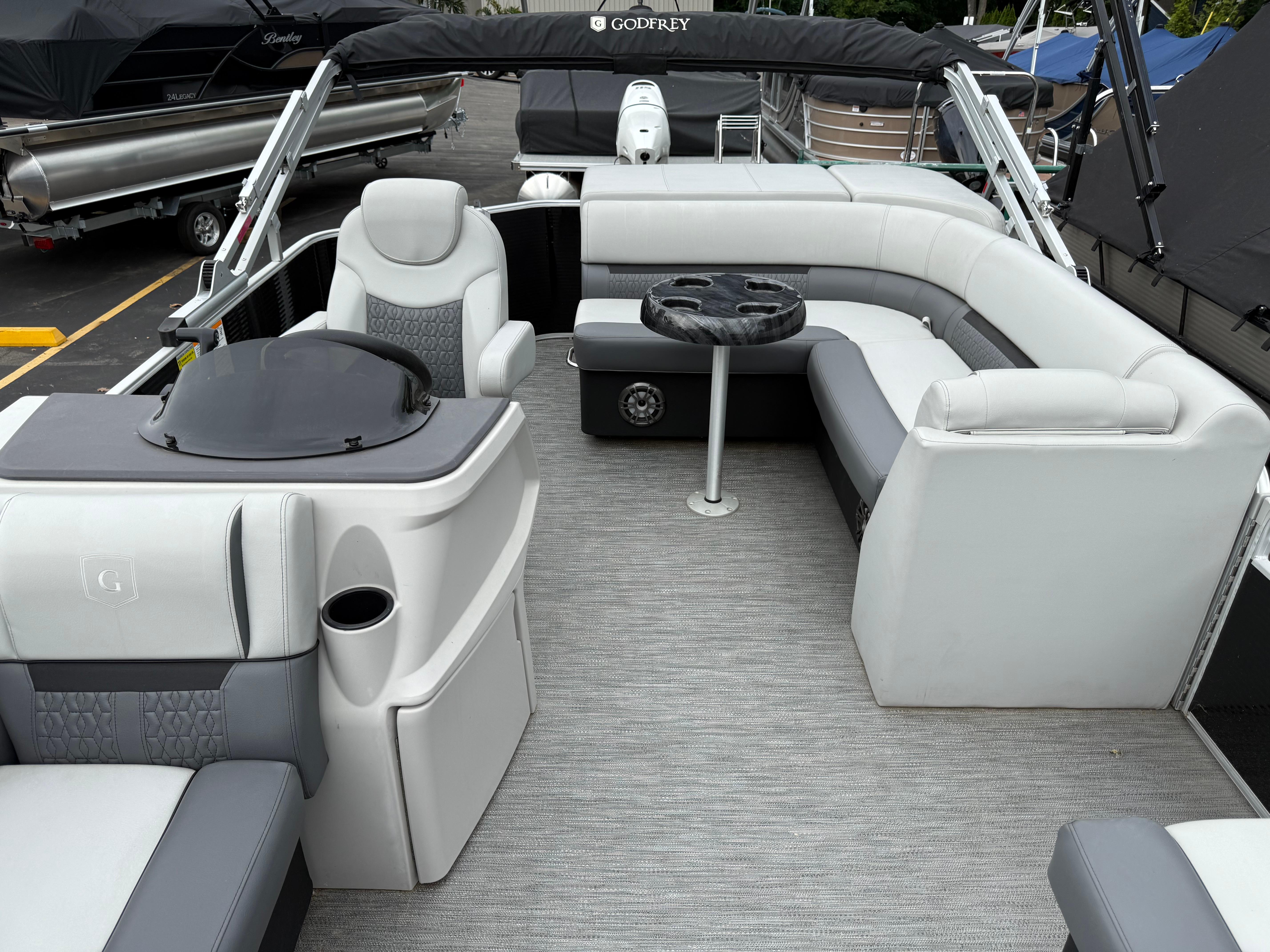2023 Godfrey Sweetwater pontoon boat interior with gray seating and table.
