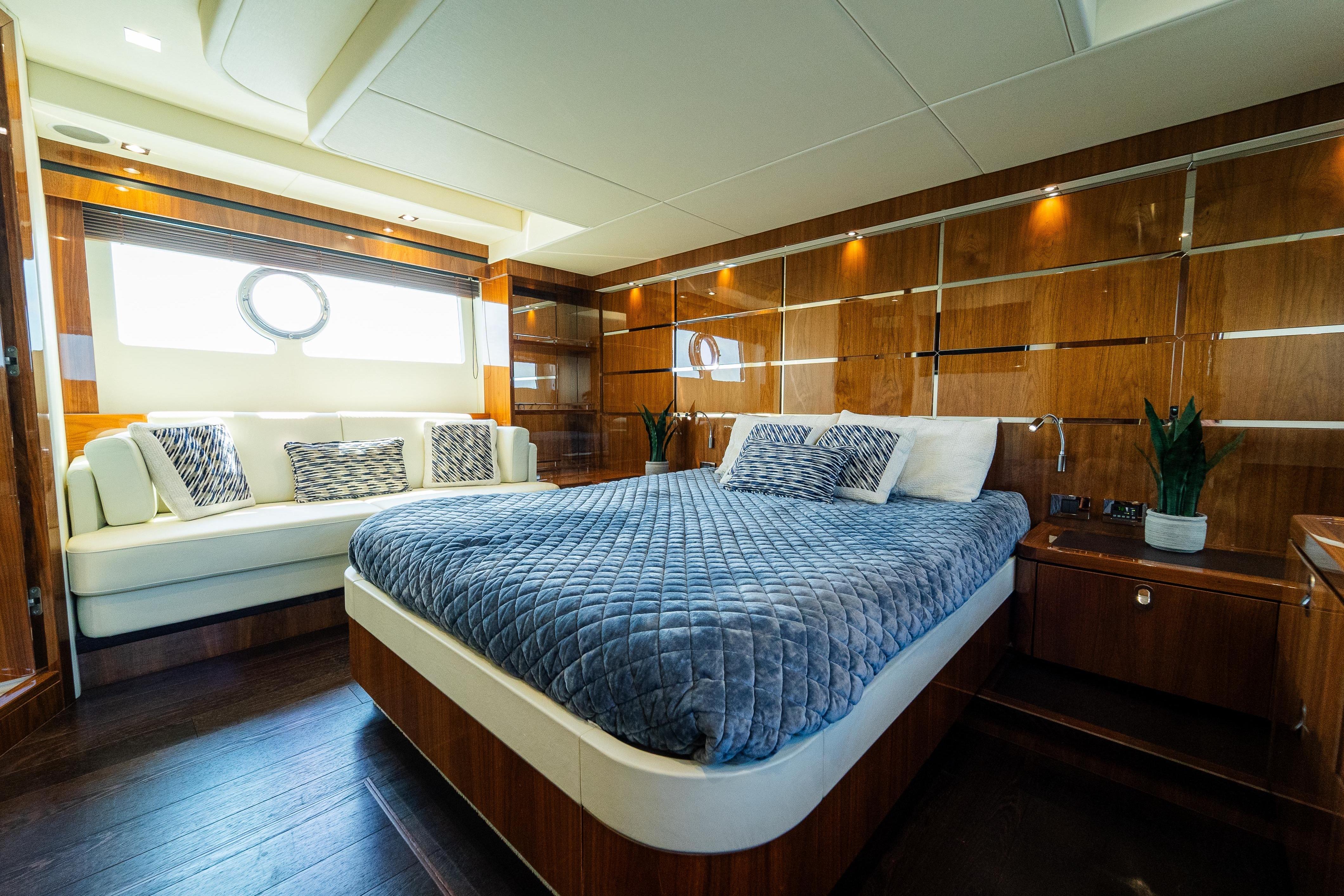 Luxurious Sunseeker Manhattan 65 yacht bedroom, 2016 model, featuring elegant wood paneling and plush bedding.