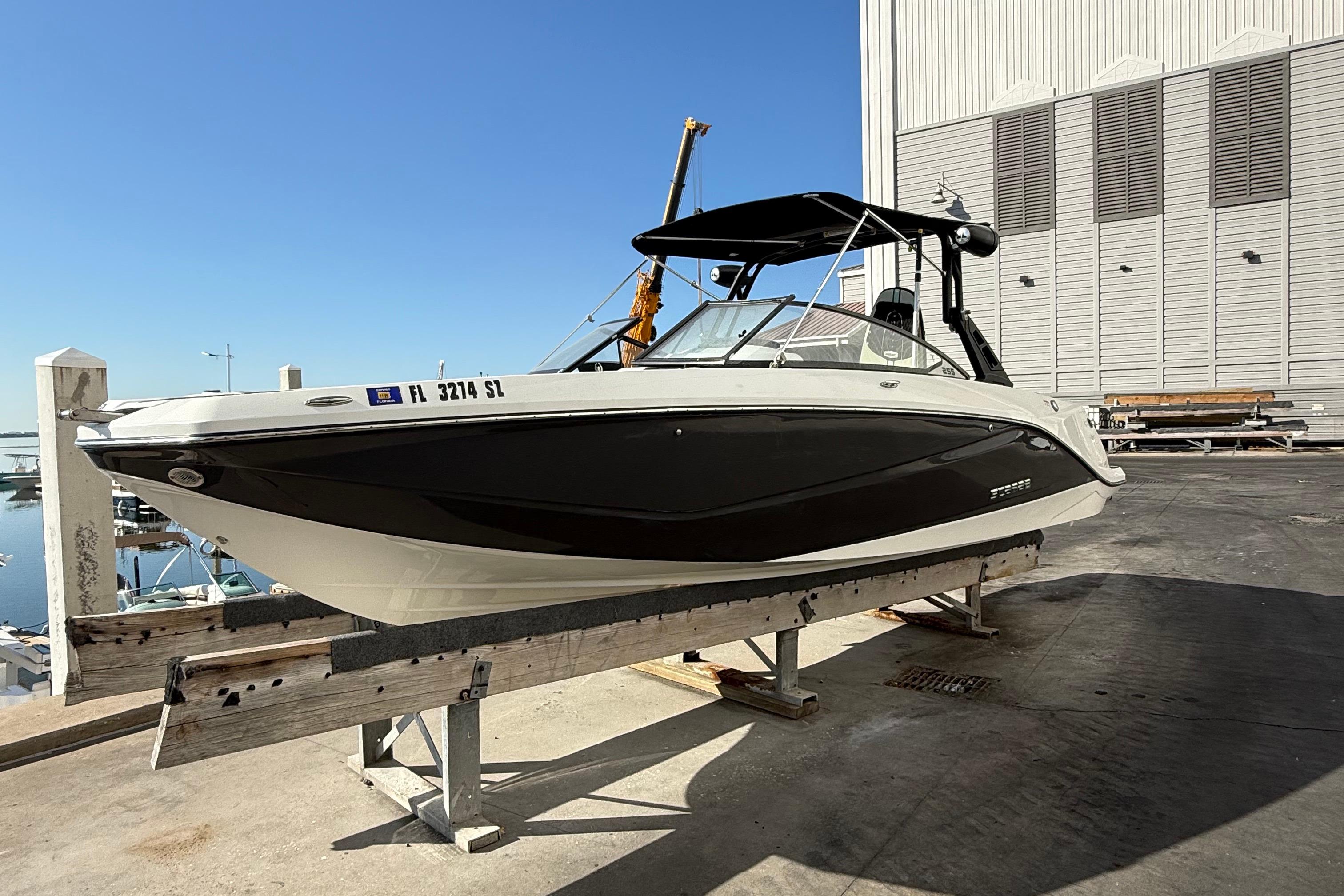 2021 Scarab 255 ID boat on dock, black and white design, sunny day.