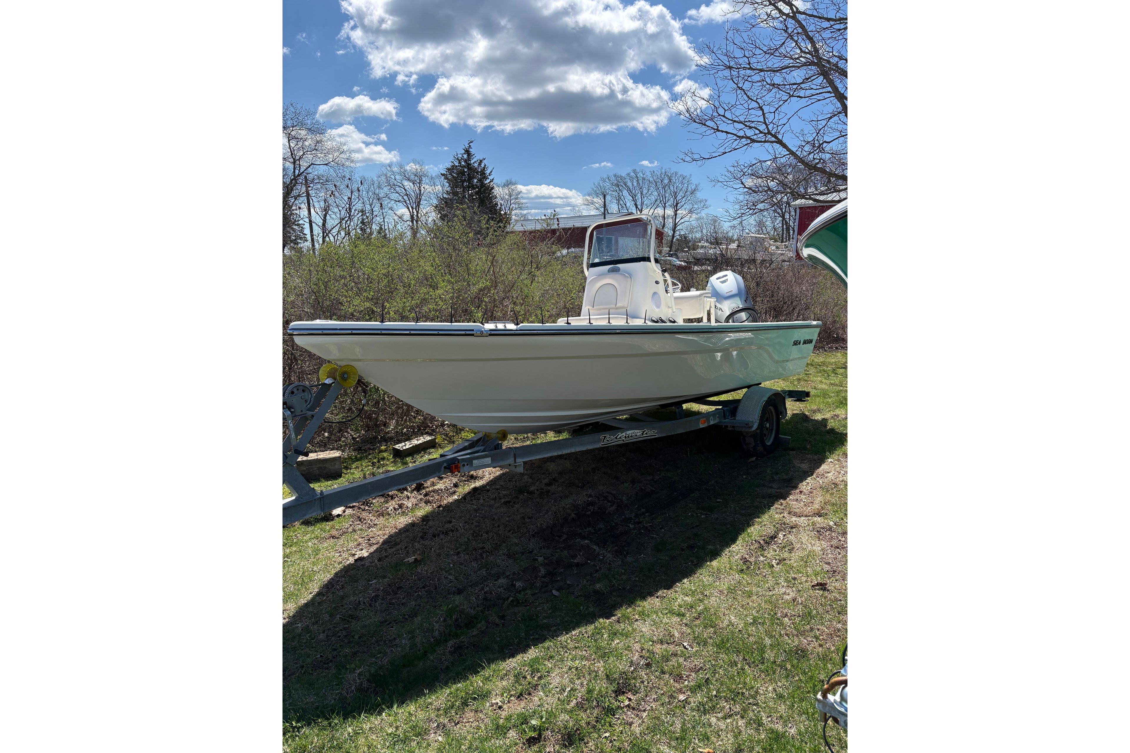 2021 Sea Born FX21 Bay boat on trailer under a sunny sky.