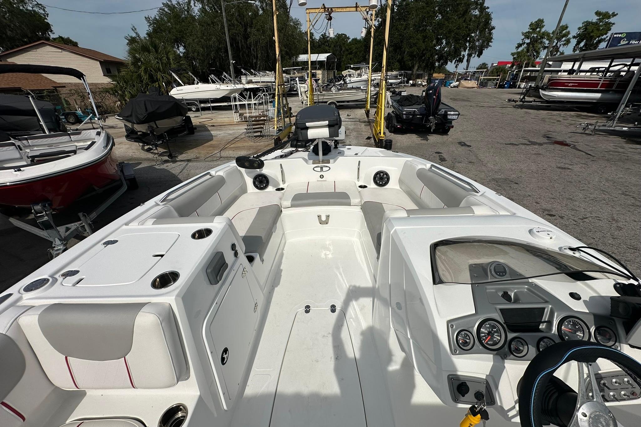 2021 Tahoe 2150 boat interior with seating and control panel, parked in a marina.