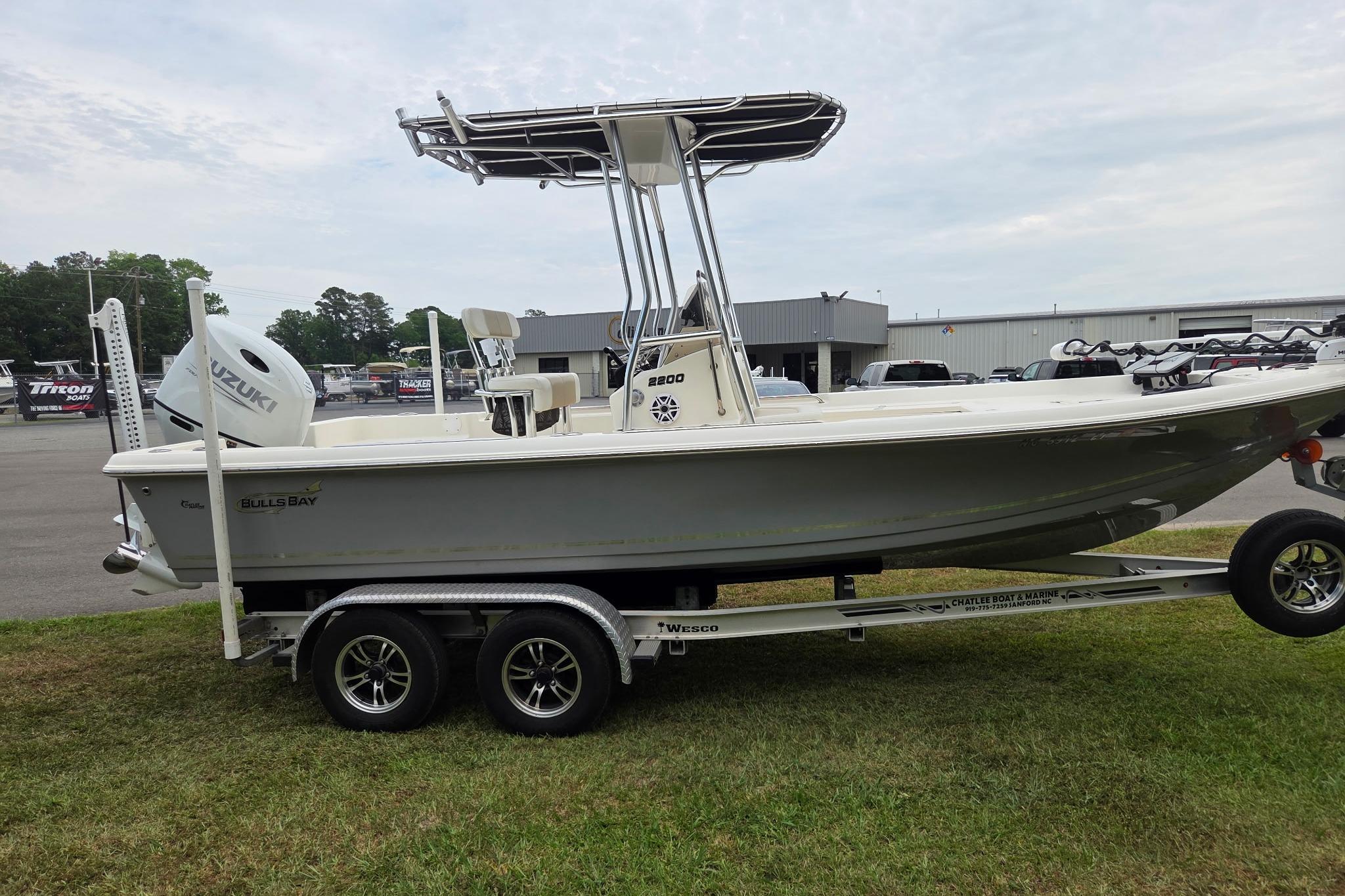 2023 Bulls Bay 2200 boat on trailer with Suzuki engine, parked outdoors.