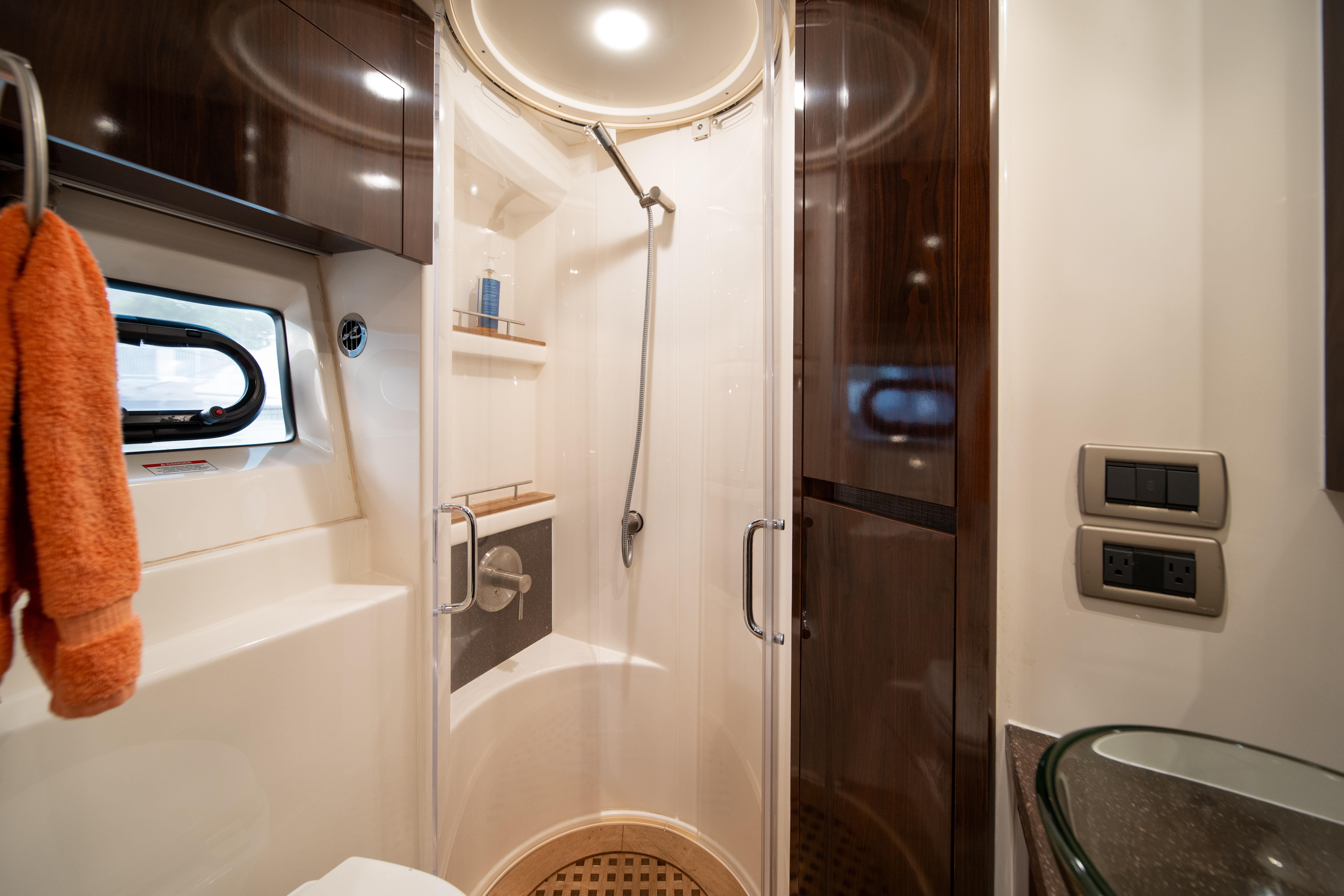 Luxurious bathroom in 2016 Sea Ray 400 Sundancer yacht with modern shower and amenities.
