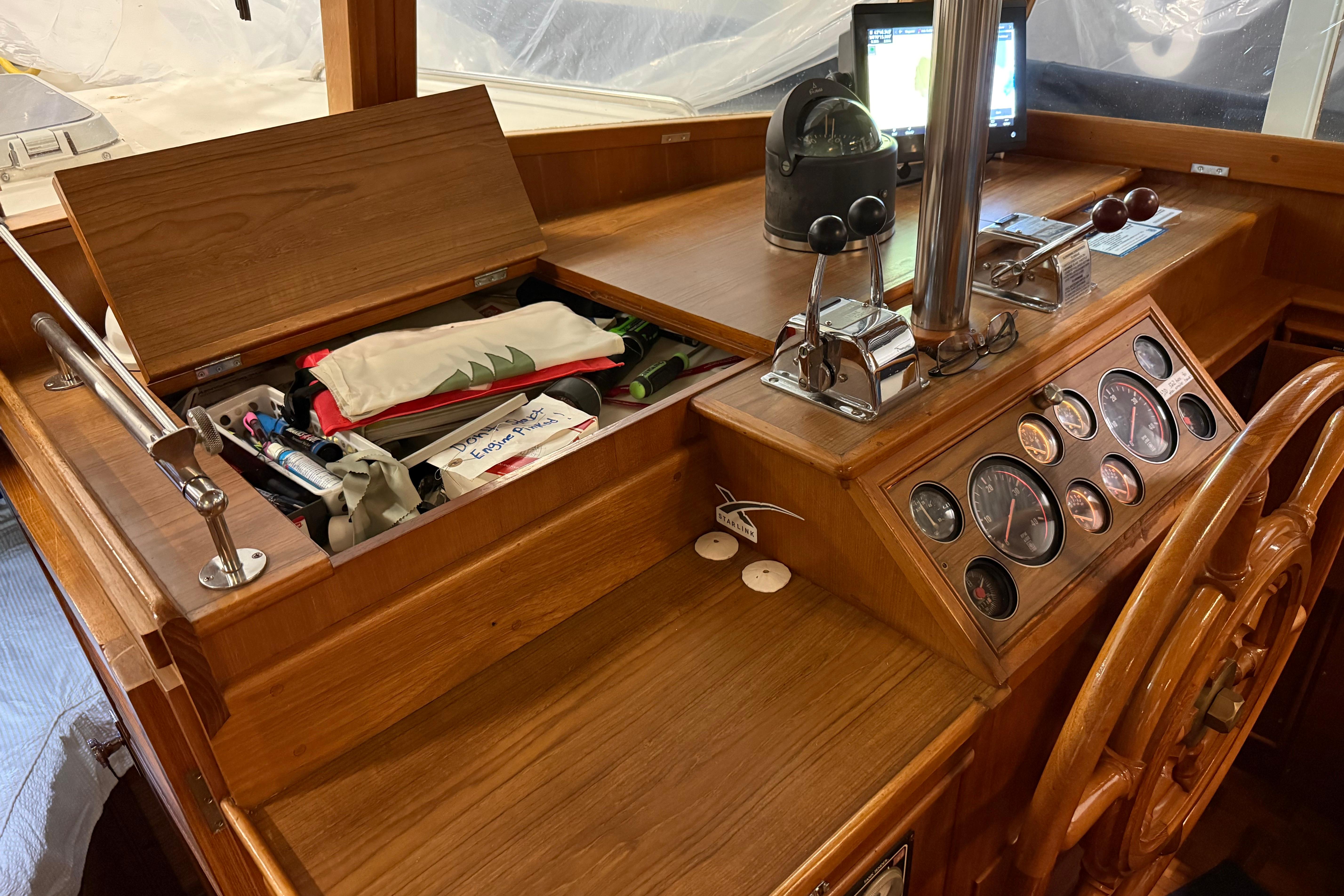 1991 Grand Banks 42 Classic helm with wooden dashboard, gauges, and navigation equipment.