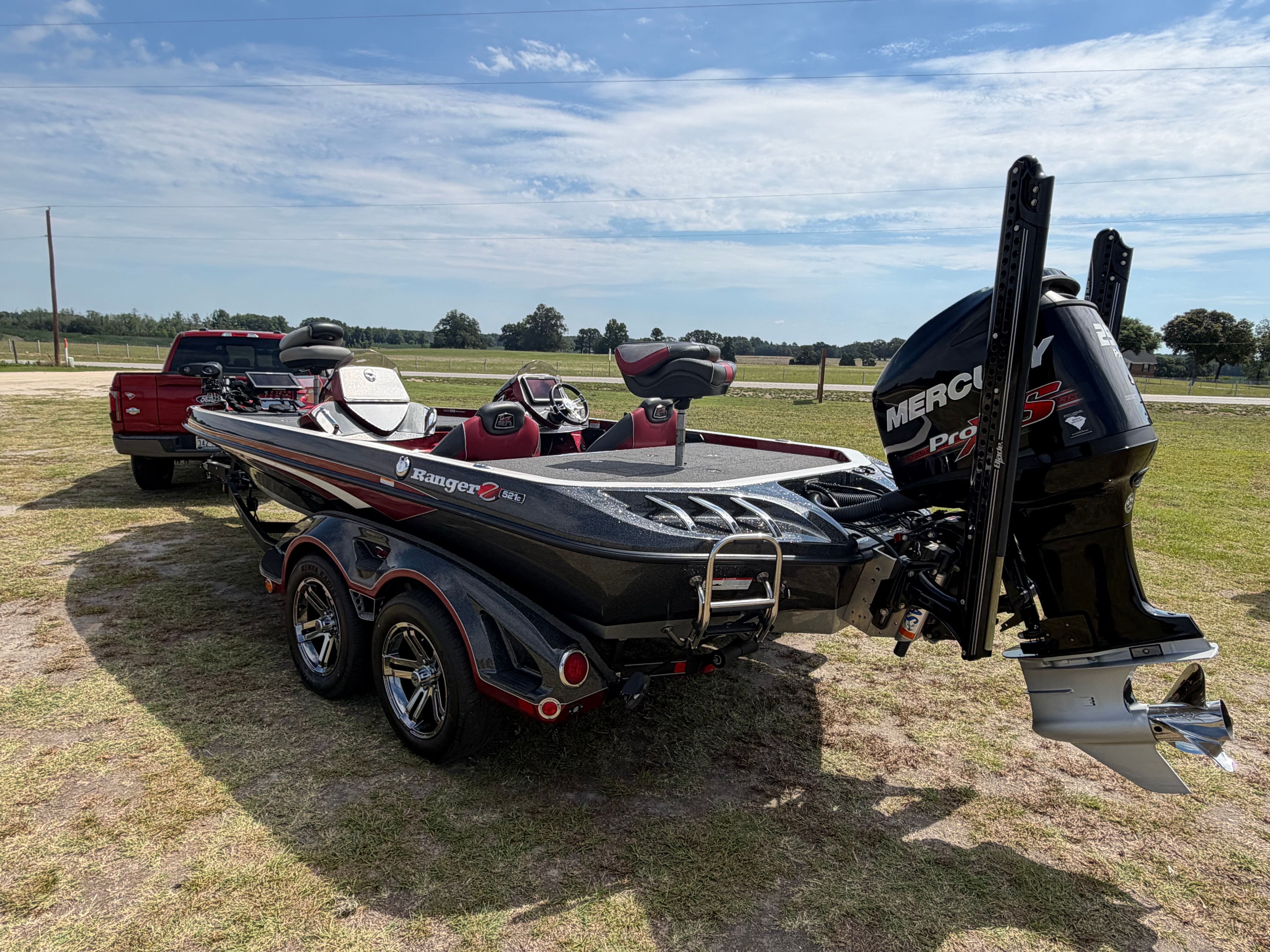 A 2018 Ranger 521C boat on a trailer next to a red pickup truck.