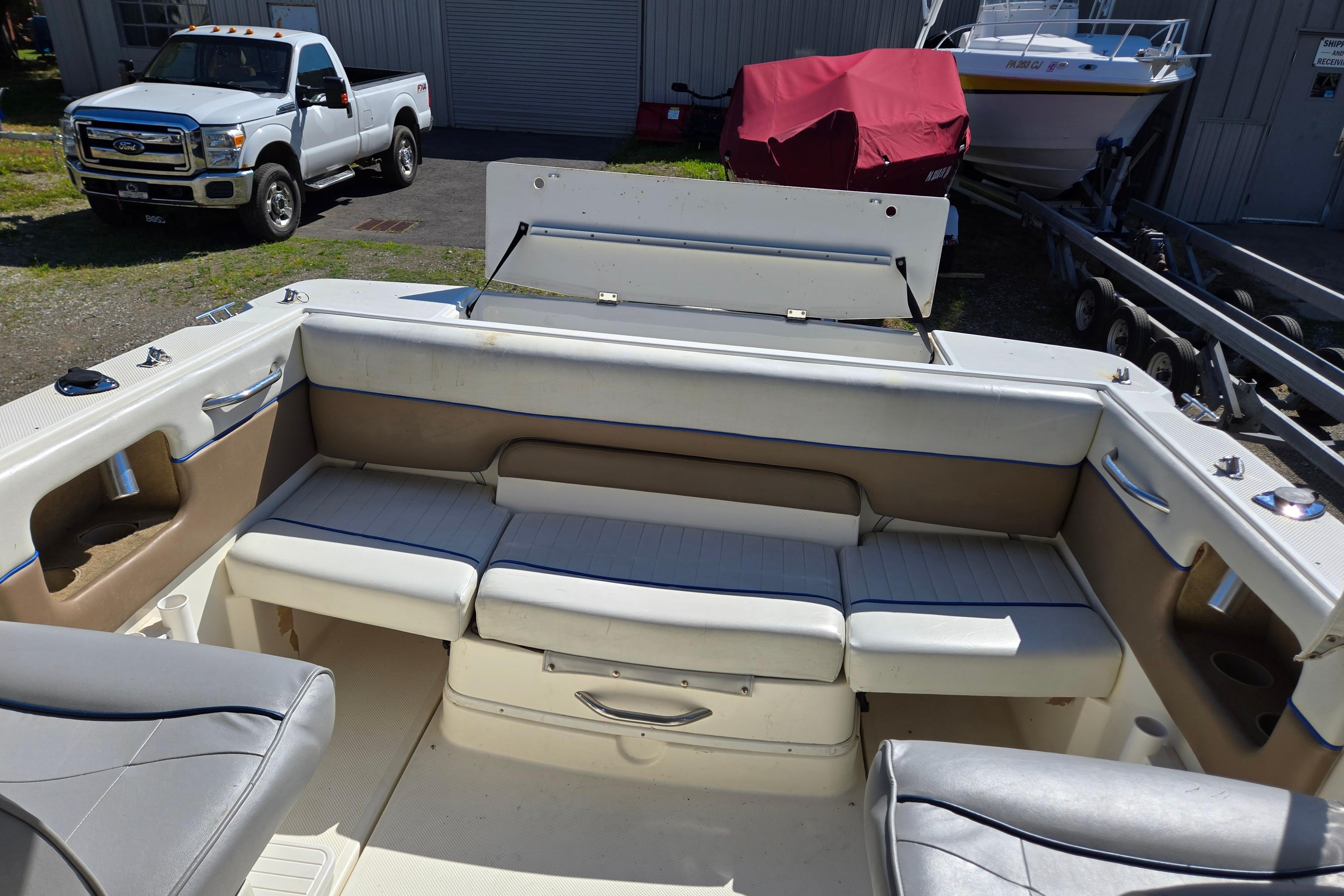 2006 Bayliner 222 Classic boat interior with seating, parked near a Ford truck.
