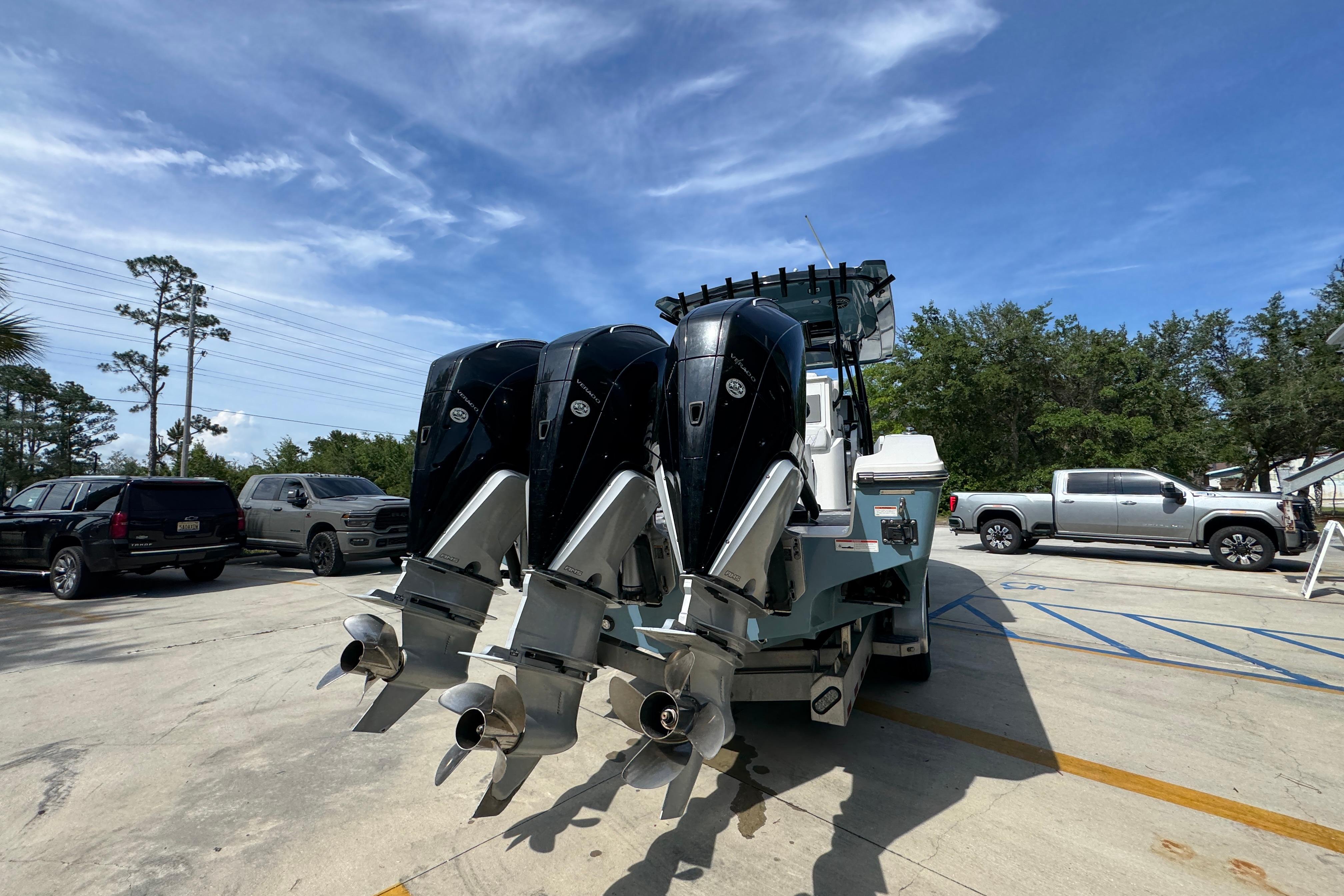 2023 Fountain 34 Tournament Edition boat with triple outboard engines in a parking lot.