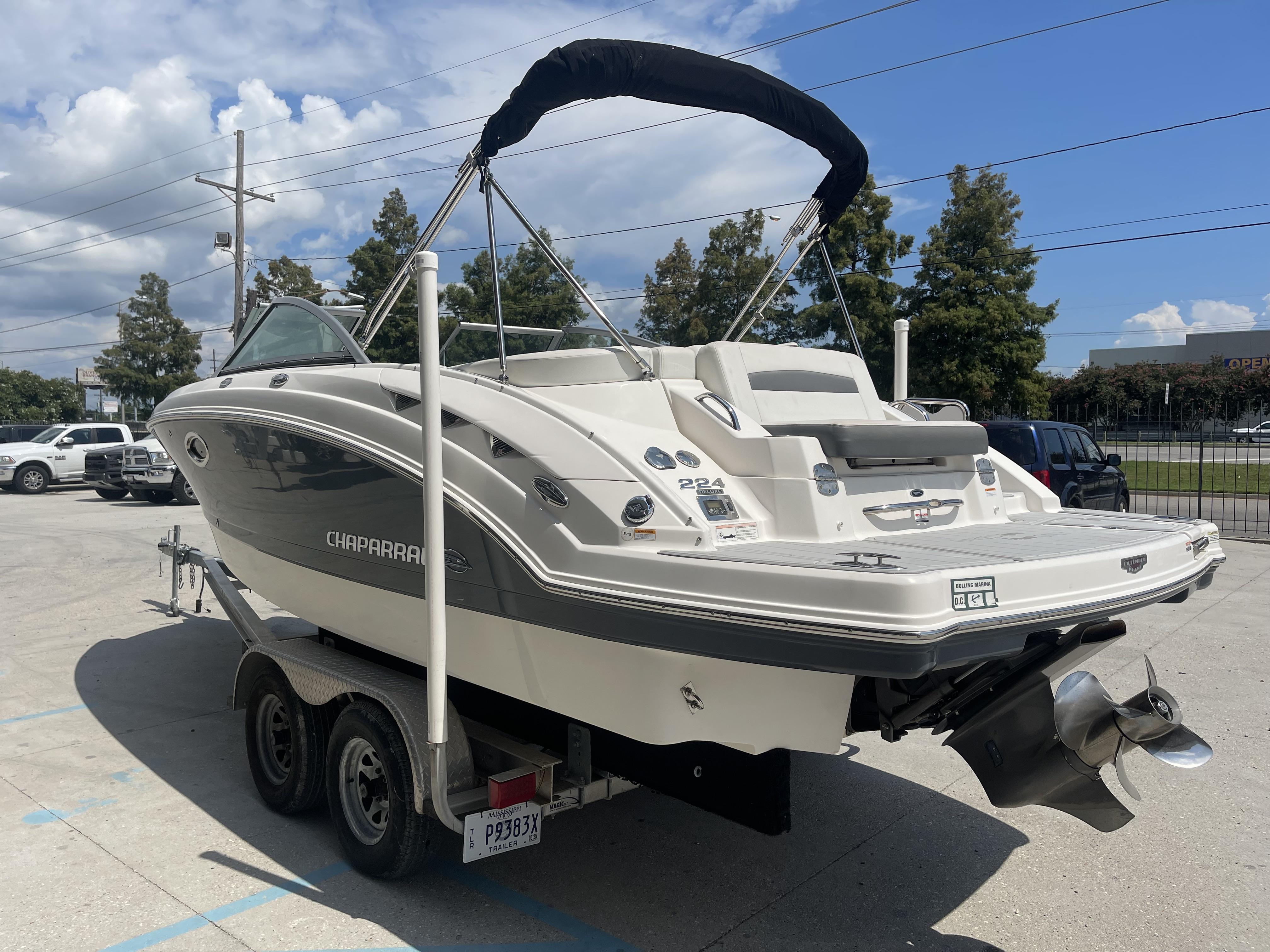 2014 Chaparral Sunesta 224 boat on trailer, parked outdoors under a clear sky.