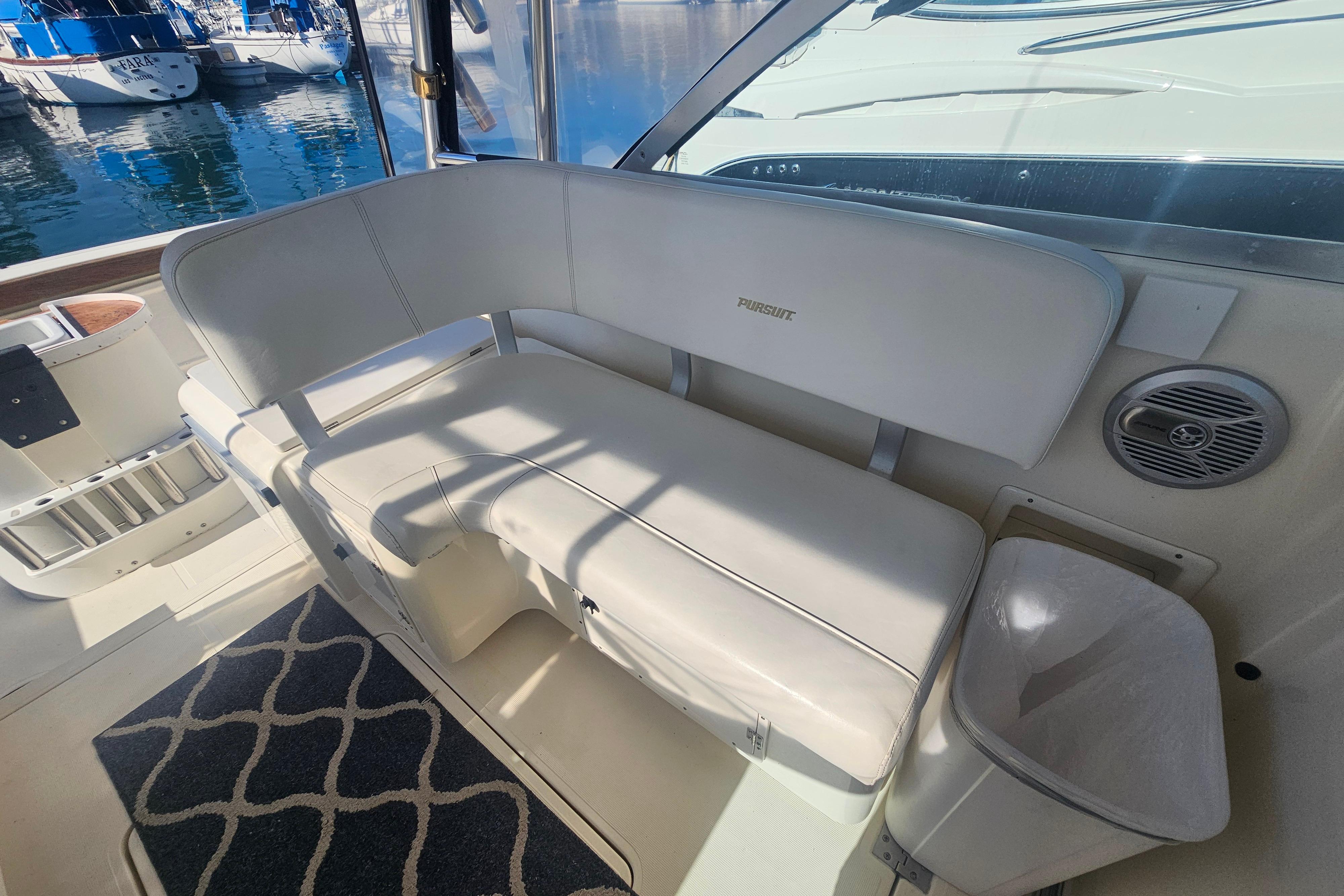 Interior of a 2001 Pursuit 3000 Express boat with white seating and nautical decor.