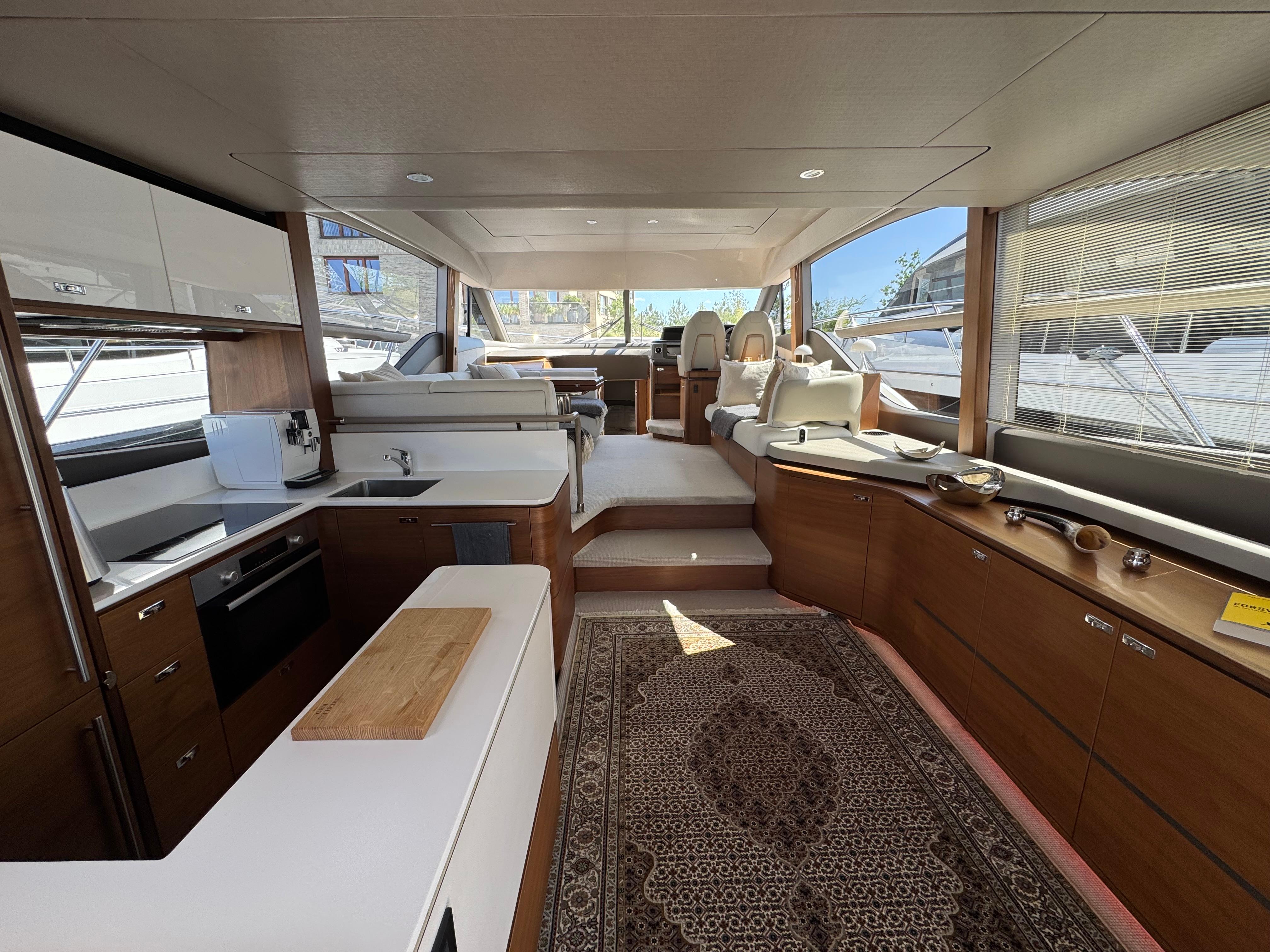 Luxurious interior of 2020 Princess F55 yacht with modern kitchen and elegant seating area.