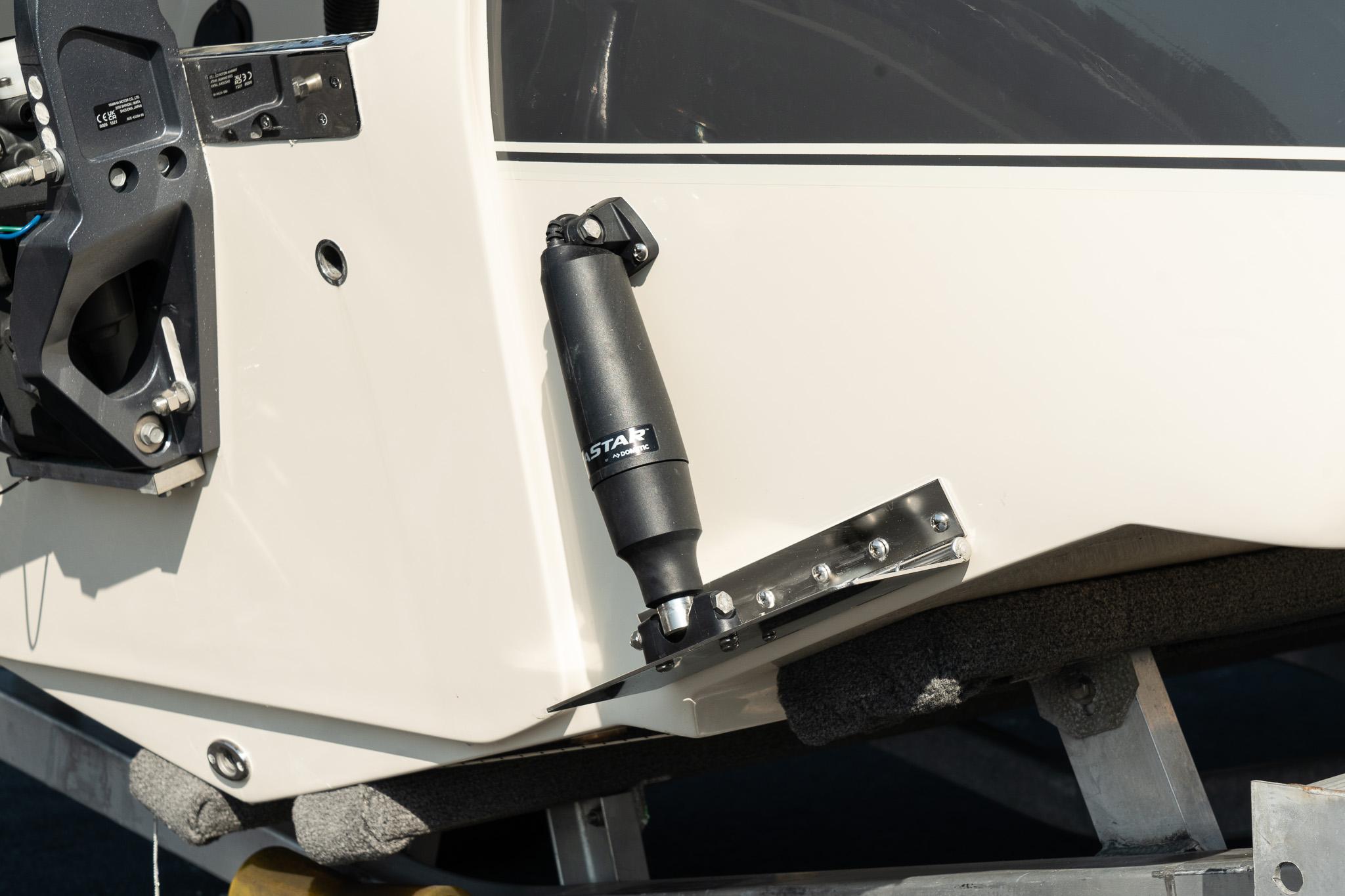 2025 Scout 195 Sportfish boat detail with trim tab and hydraulic actuator.