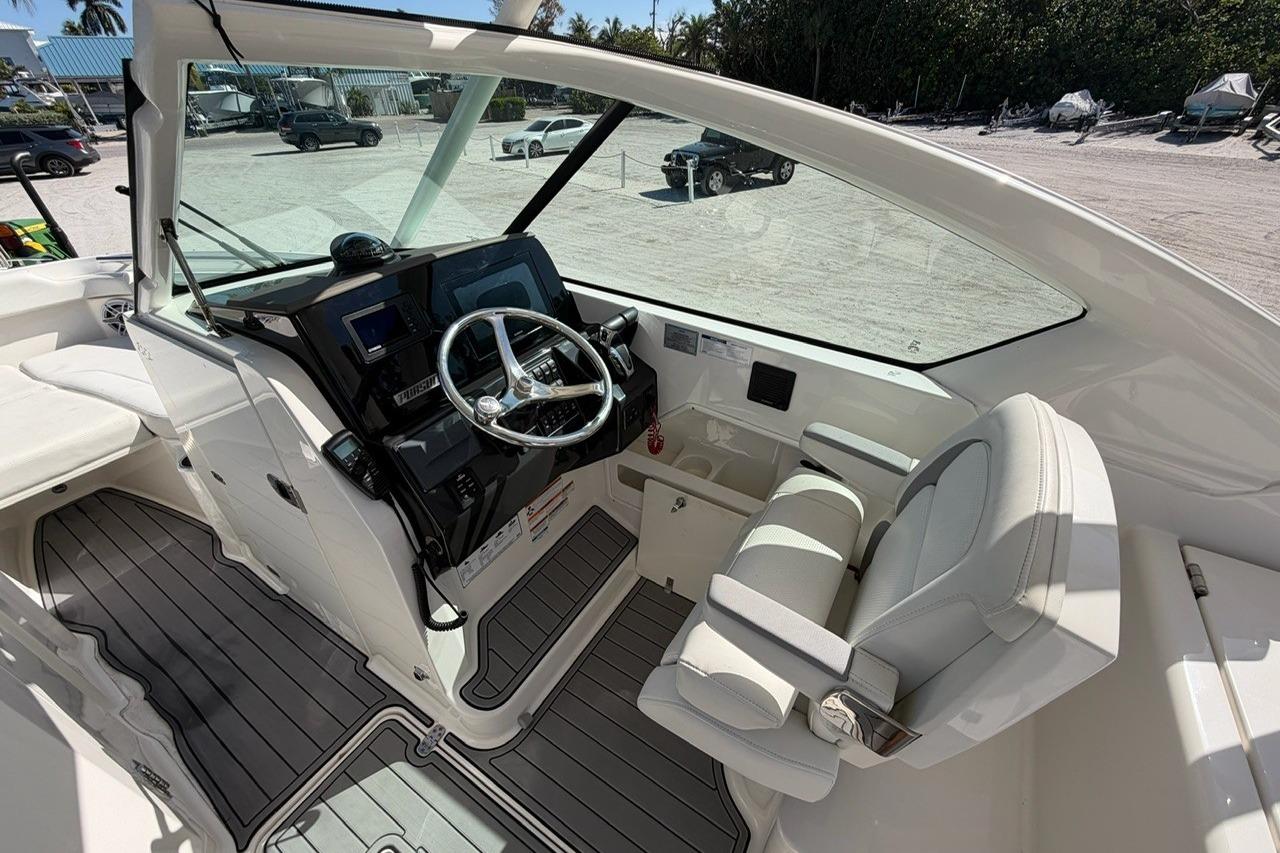 2021 Pursuit DC 266 Dual Console boat interior with steering wheel and seating.