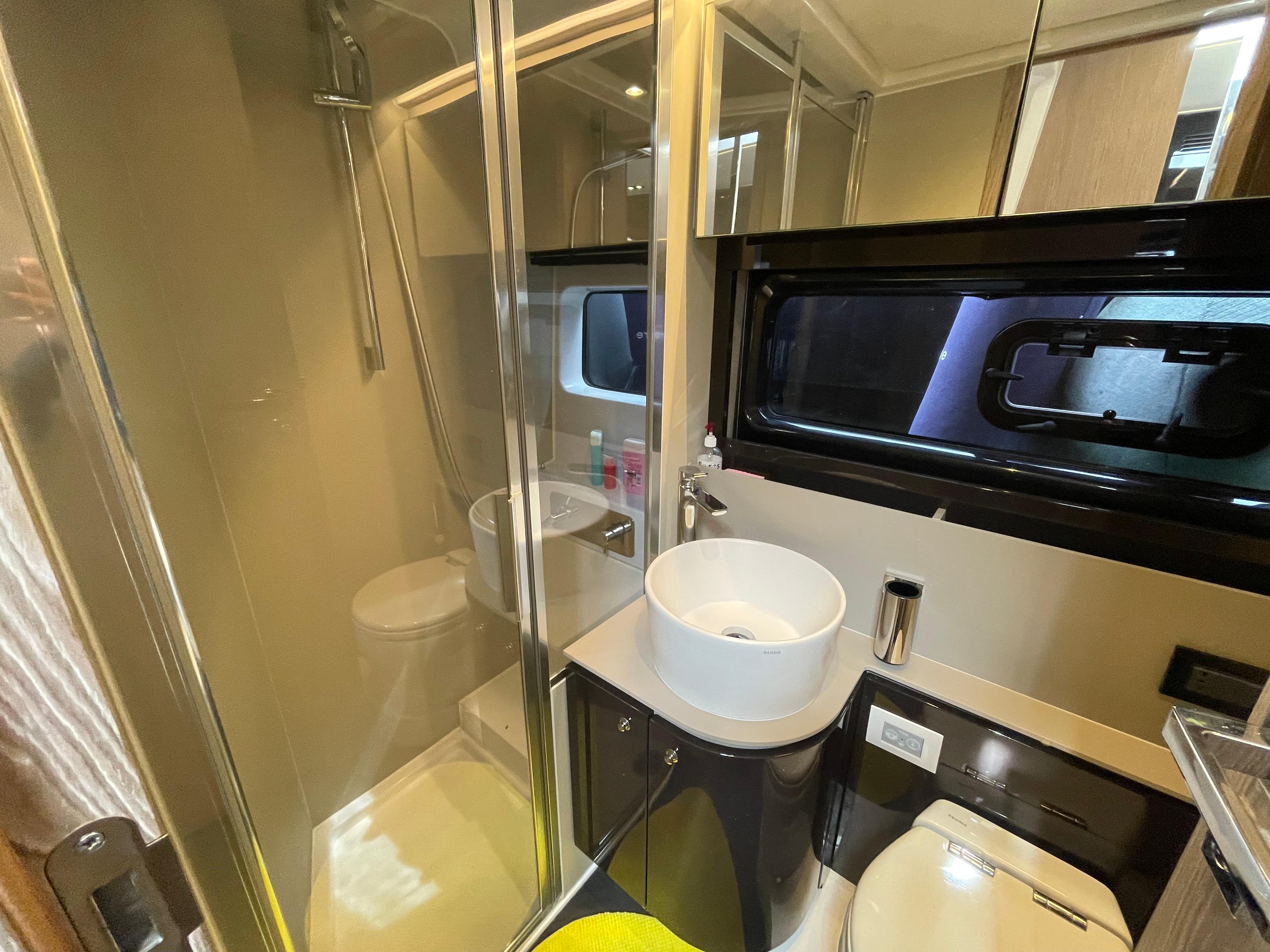 Luxurious bathroom in 2018 Azimut Atlantis 51 yacht with modern fixtures and glass shower.
