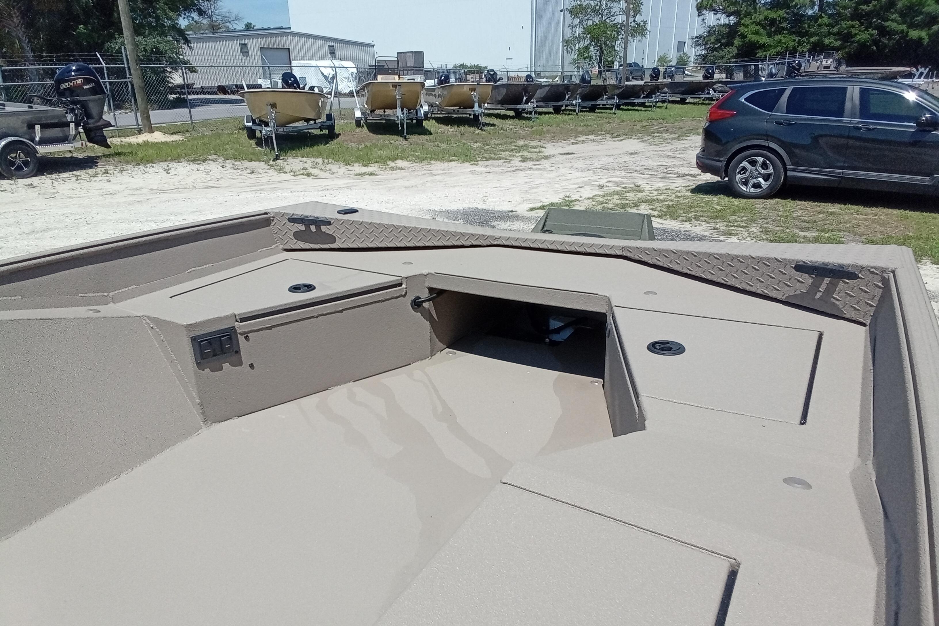 2026 Alweld 1652 Invader boat interior with storage compartments, parked outdoors.